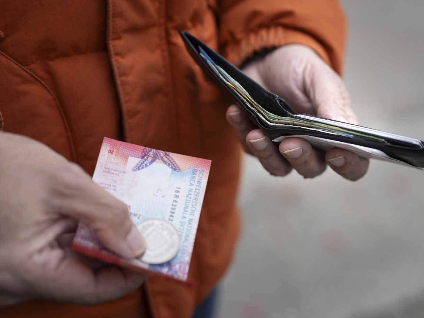 persona con contanti svizzeri in mano
