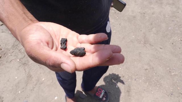 Mano mostra composti solidi di colore nero