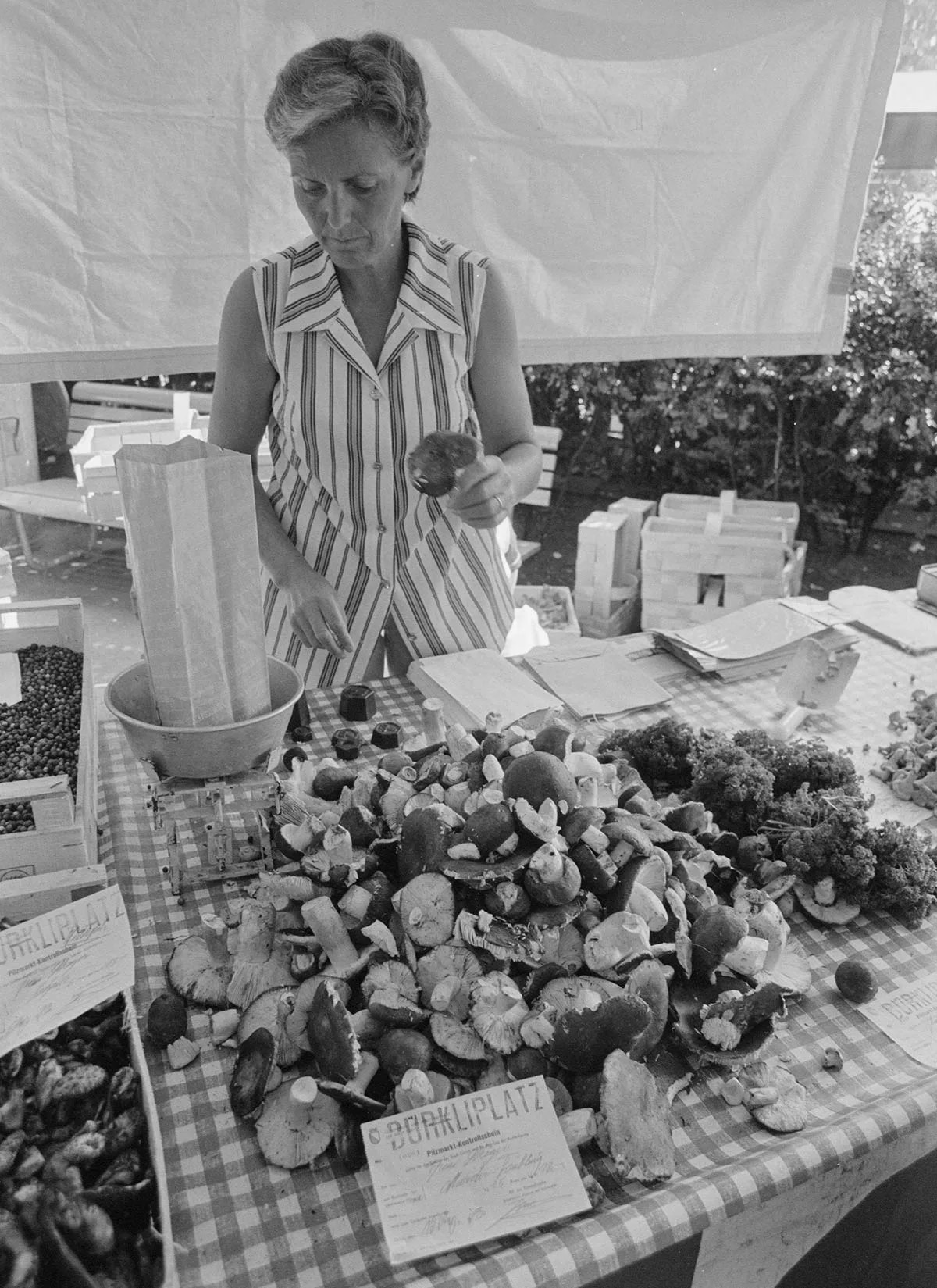 Femme vendant des champignons sur un marché.