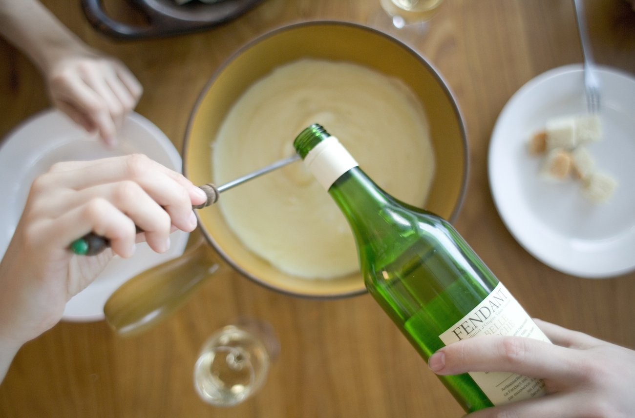 Persona versa vino in un caquelon di fondue