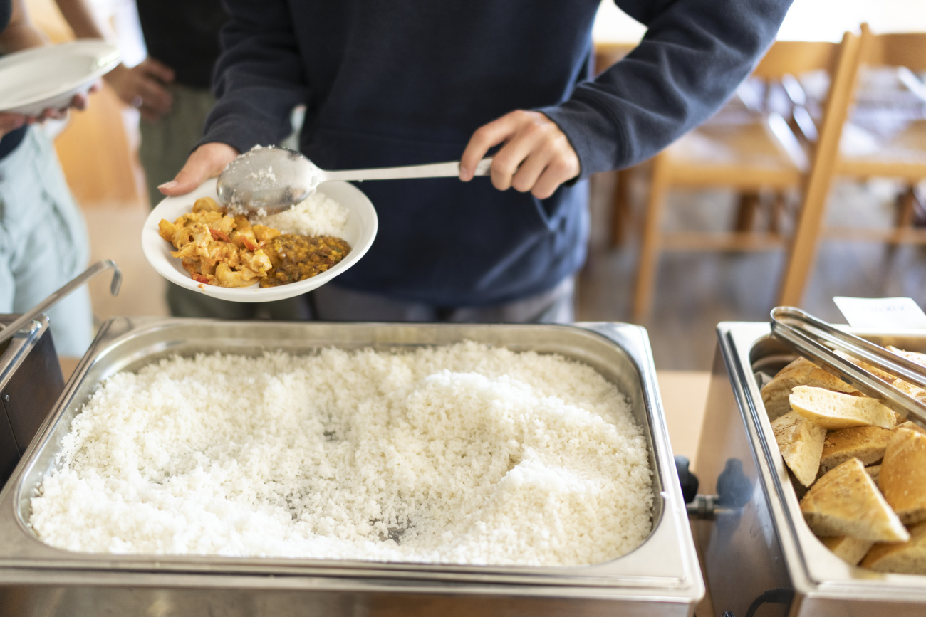 persona si serve del cibo in una mensa