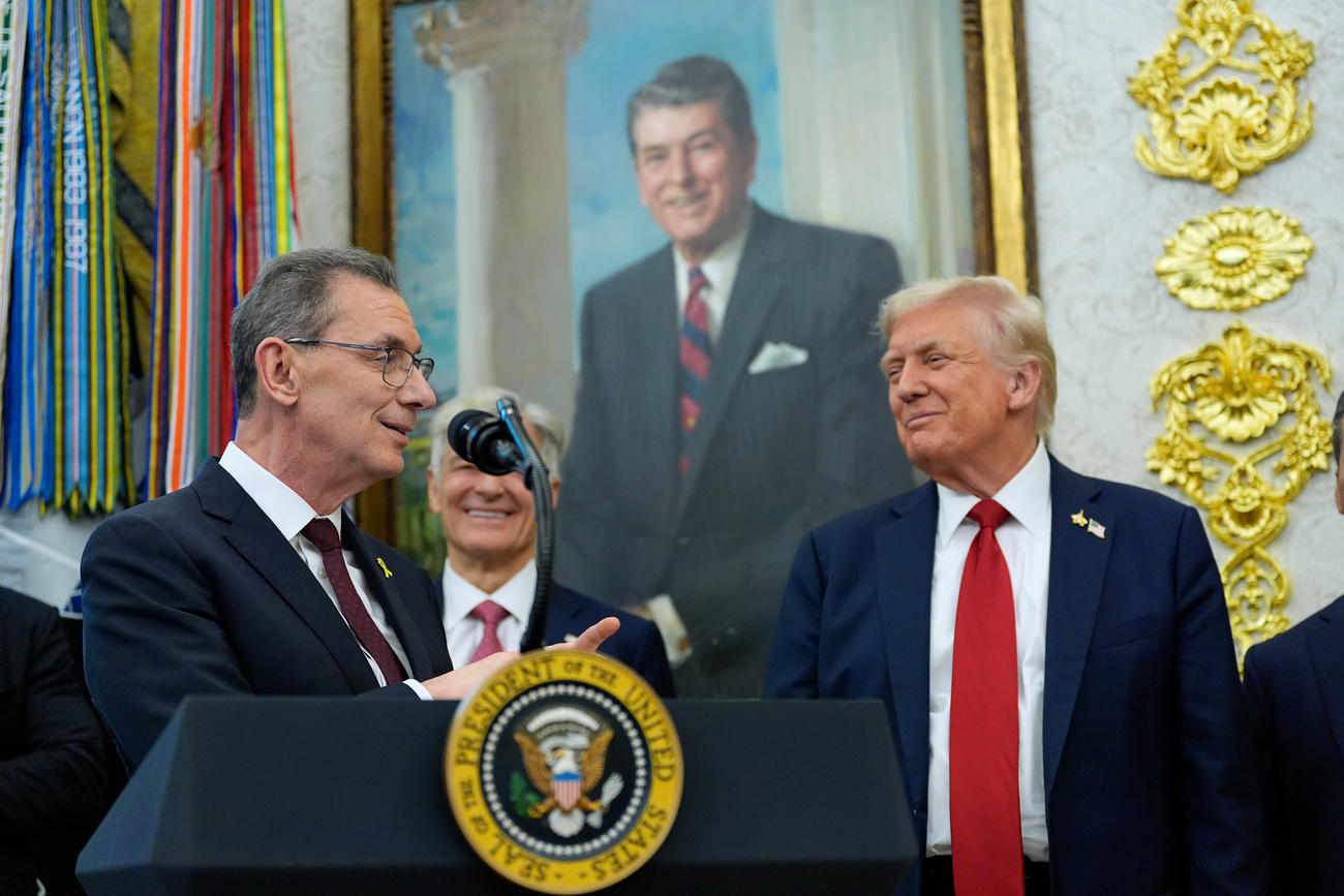 Men at a lectern smile.