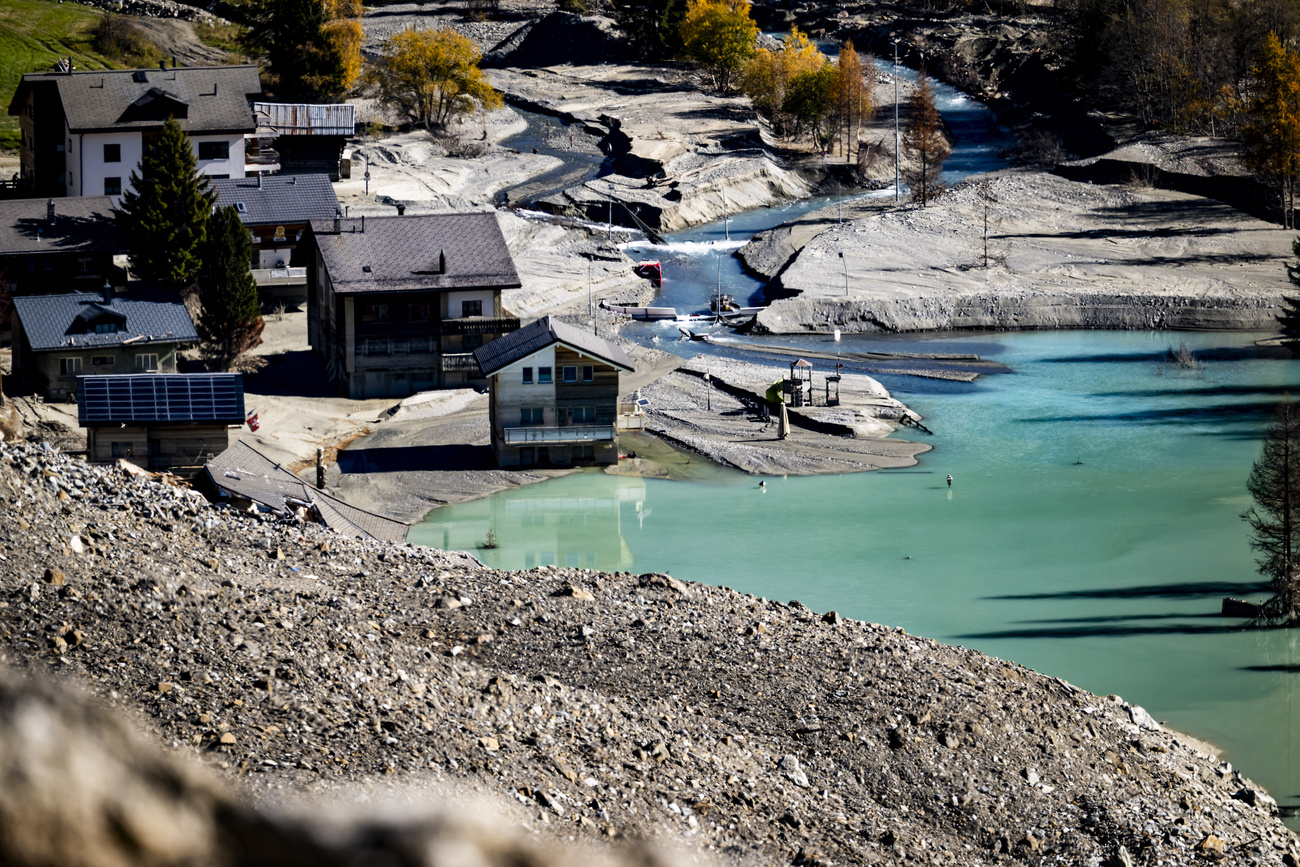 A few houses remain at the edge of the landslide.