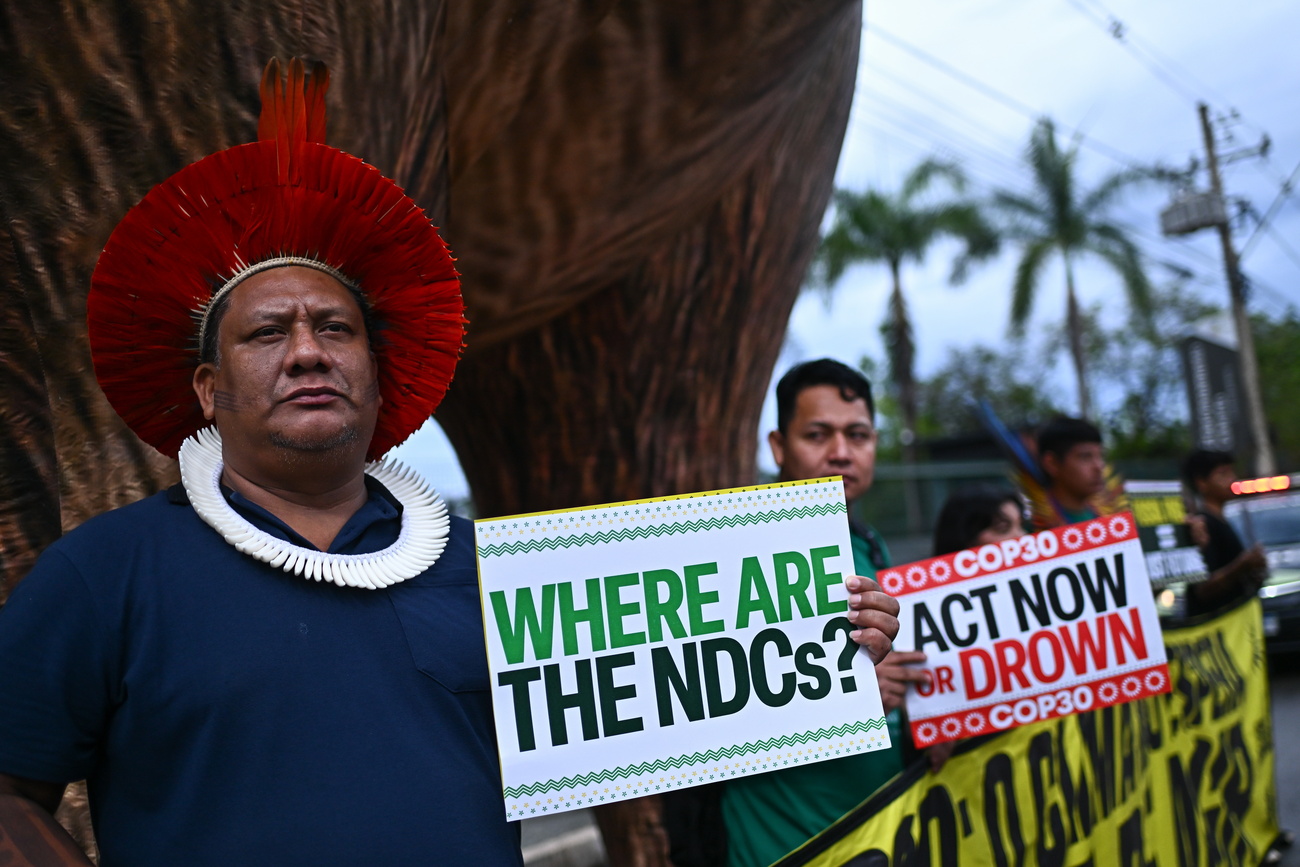 Protesters hold signs reading ‘Where are the NDCs?’ and ‘Act now or drown’