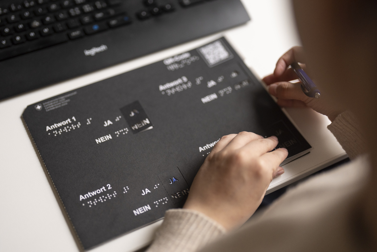 Eine Frau füllt einen Stimmzettel mithilfe einer Schablone aus