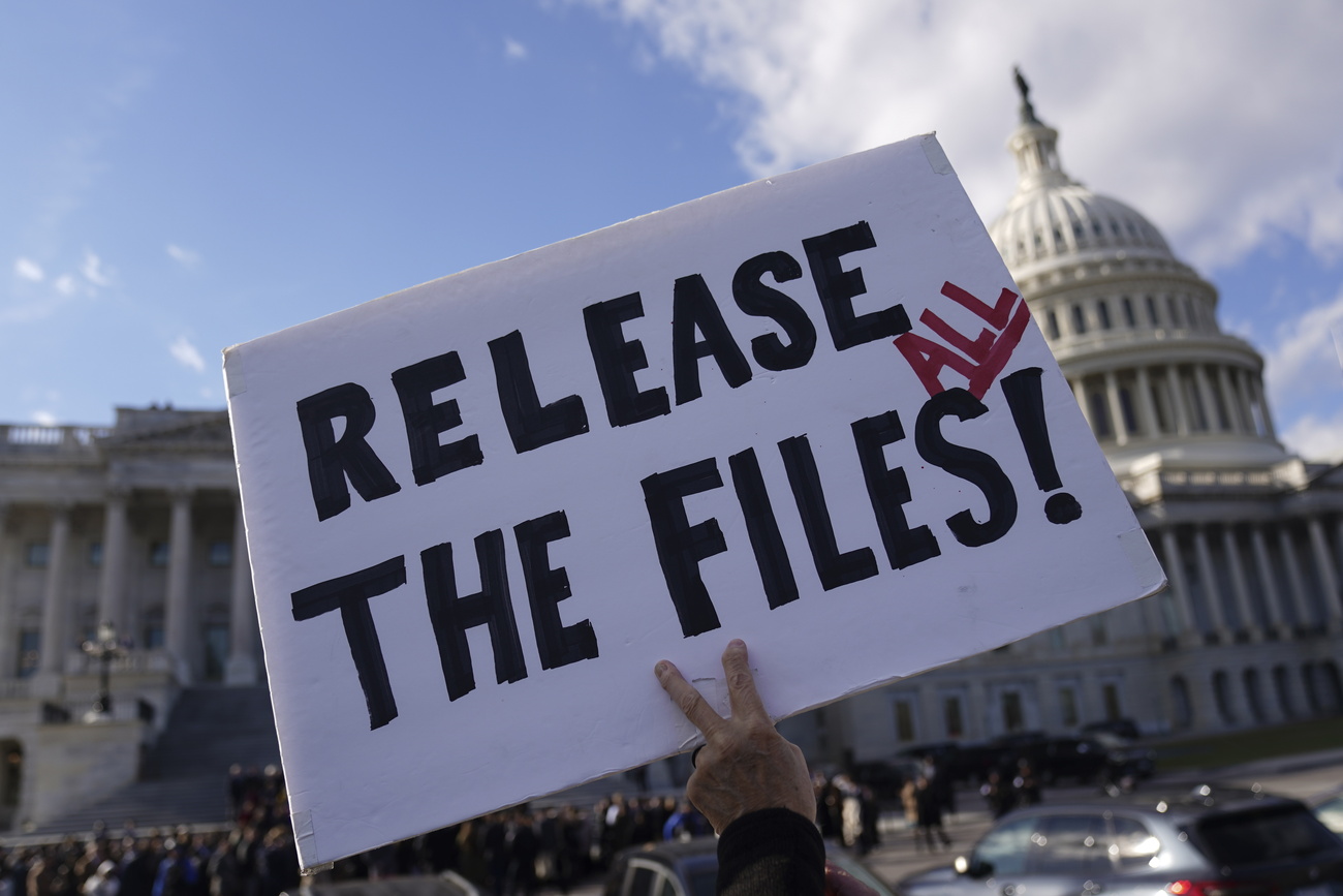 cartello con scritta release all the files tenuto da un manifestante di fronte al governo statunitense