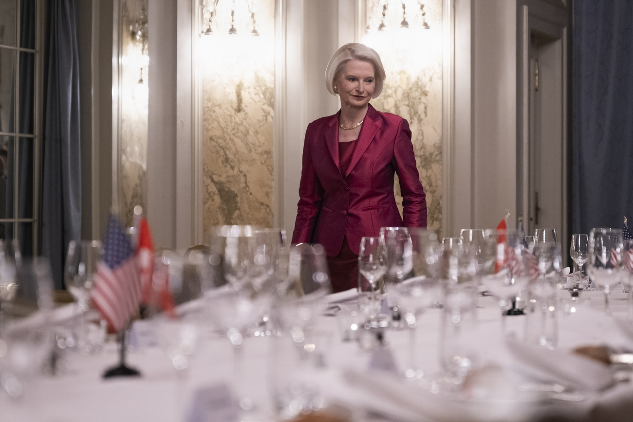 Donna in abito rosso guarda un tavolo apparechiato