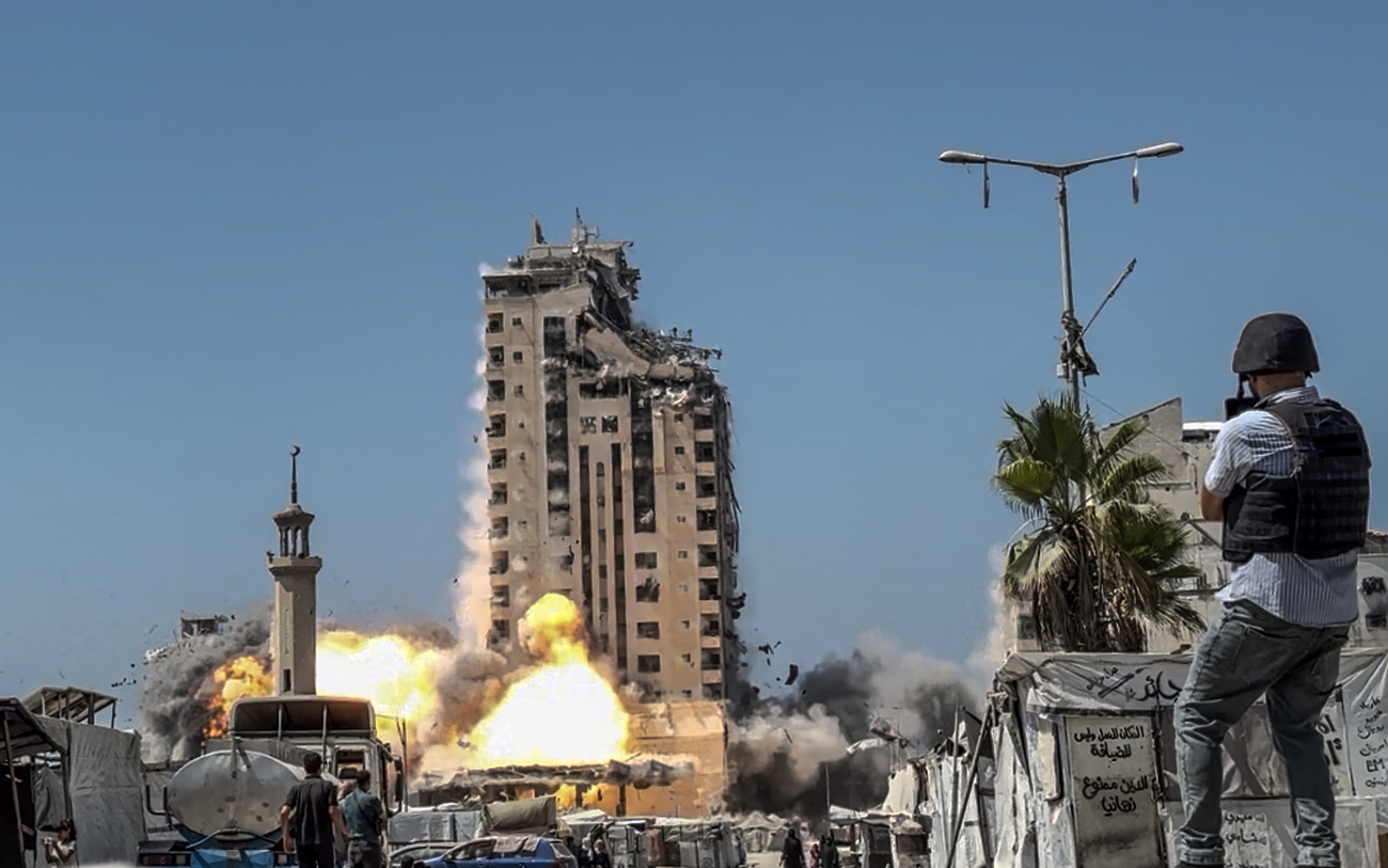 Photo of a journalist and explosion in the background