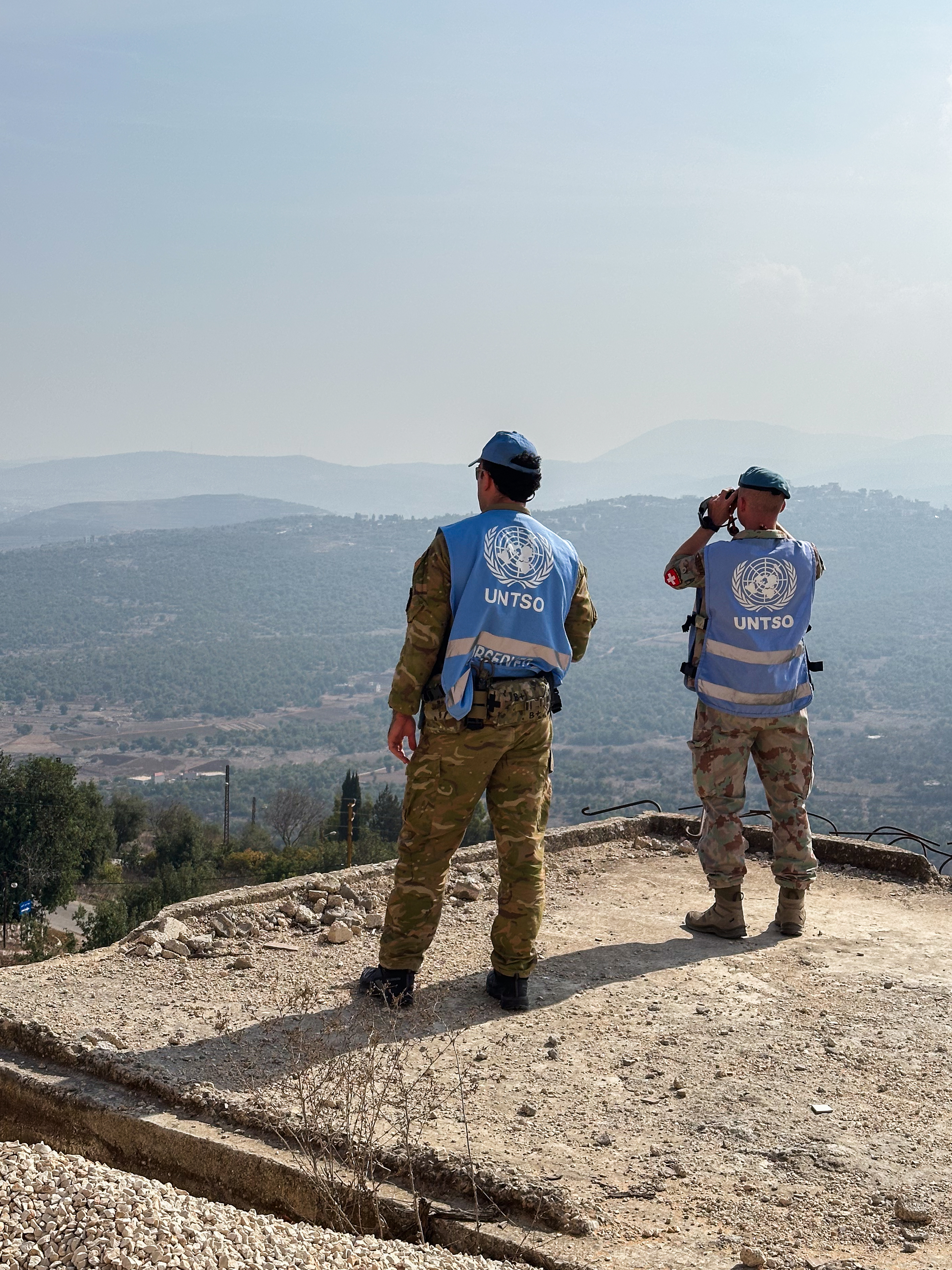 Zwei Personen in blauen Westen überblicken eine Landschaft