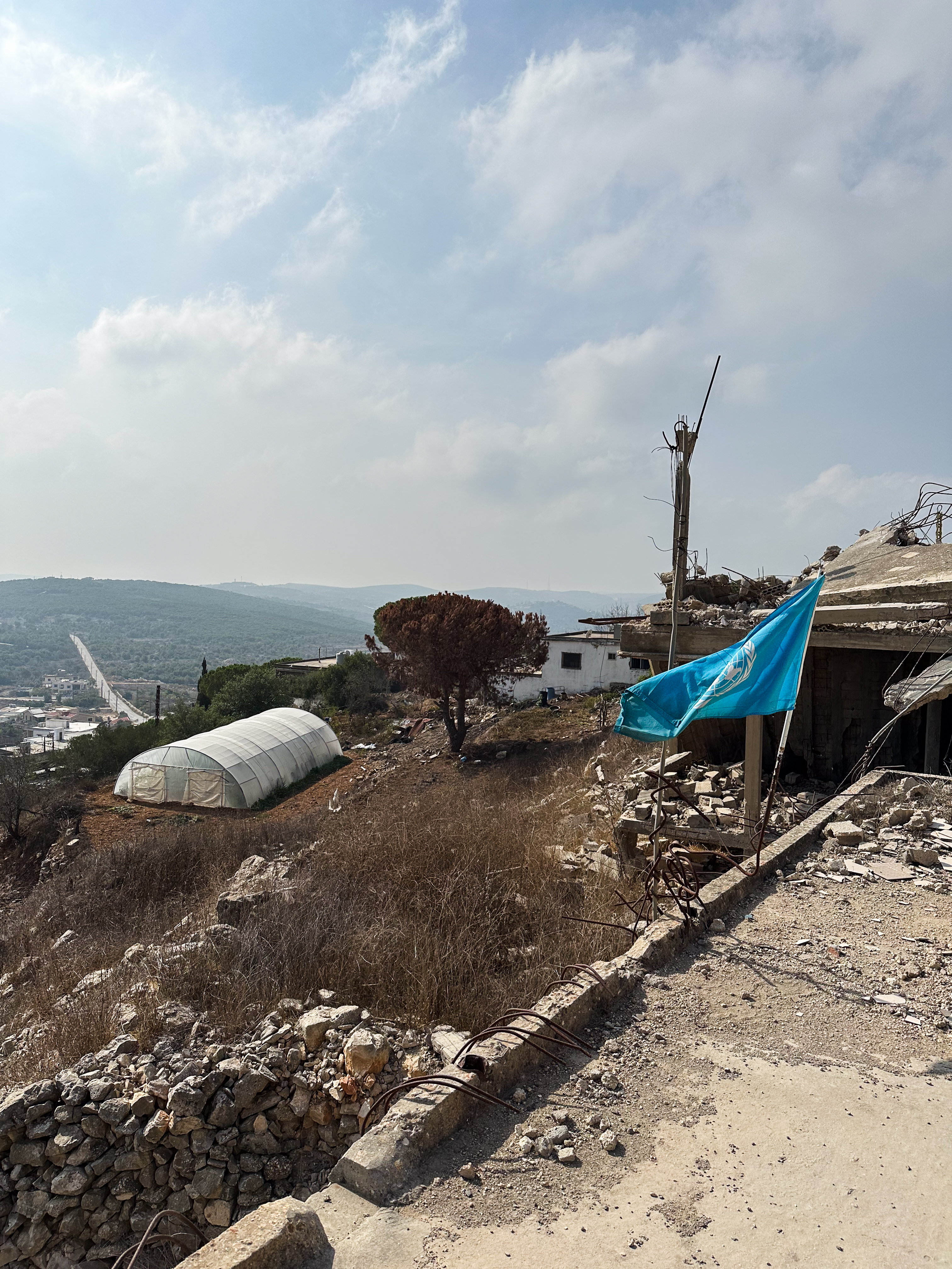 Eine UNO-Flagge neben einem beschädigten Gebäude