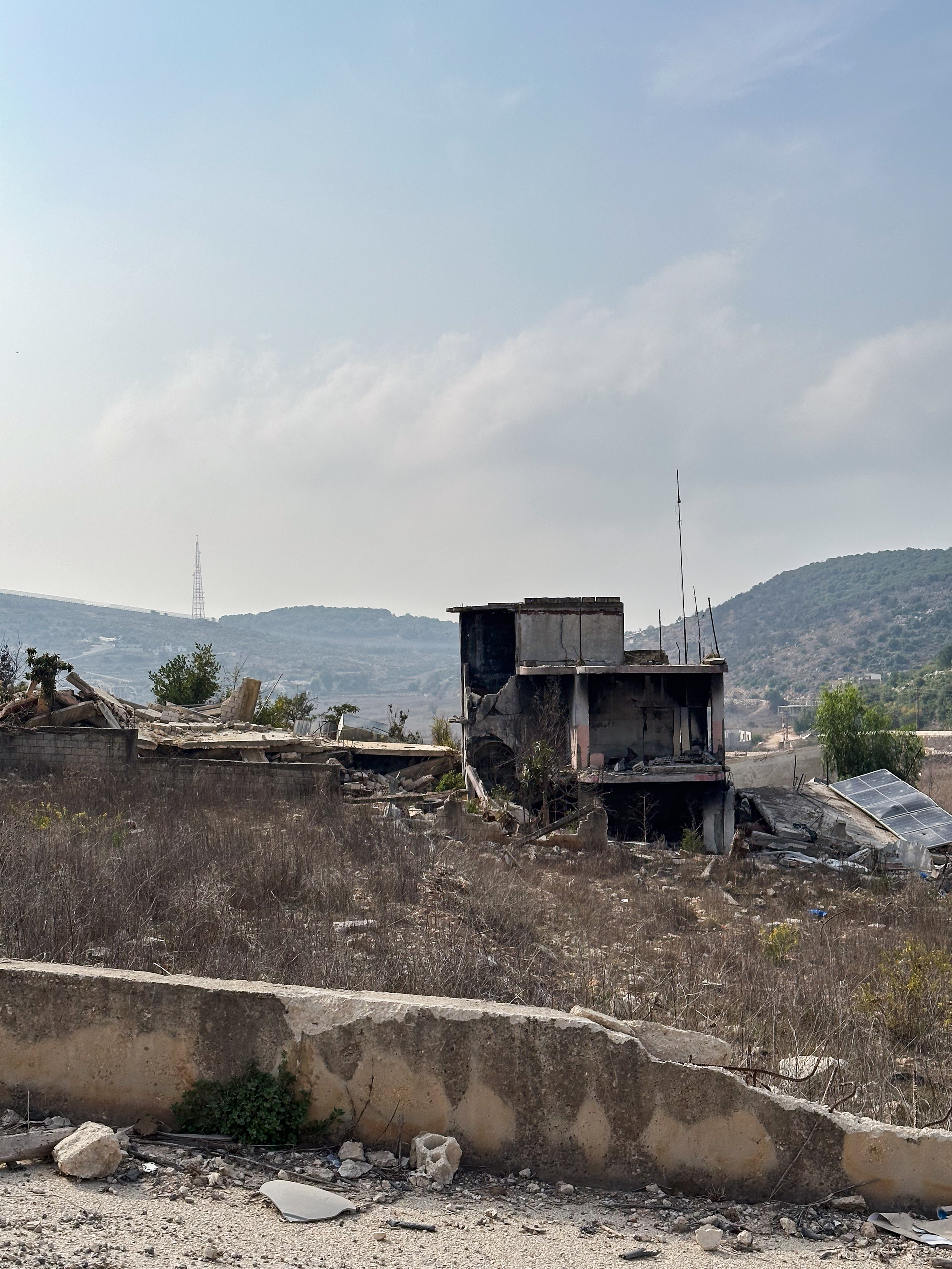 Verfallenes Gebäude umgeben von trockenem Gras und Trümmern