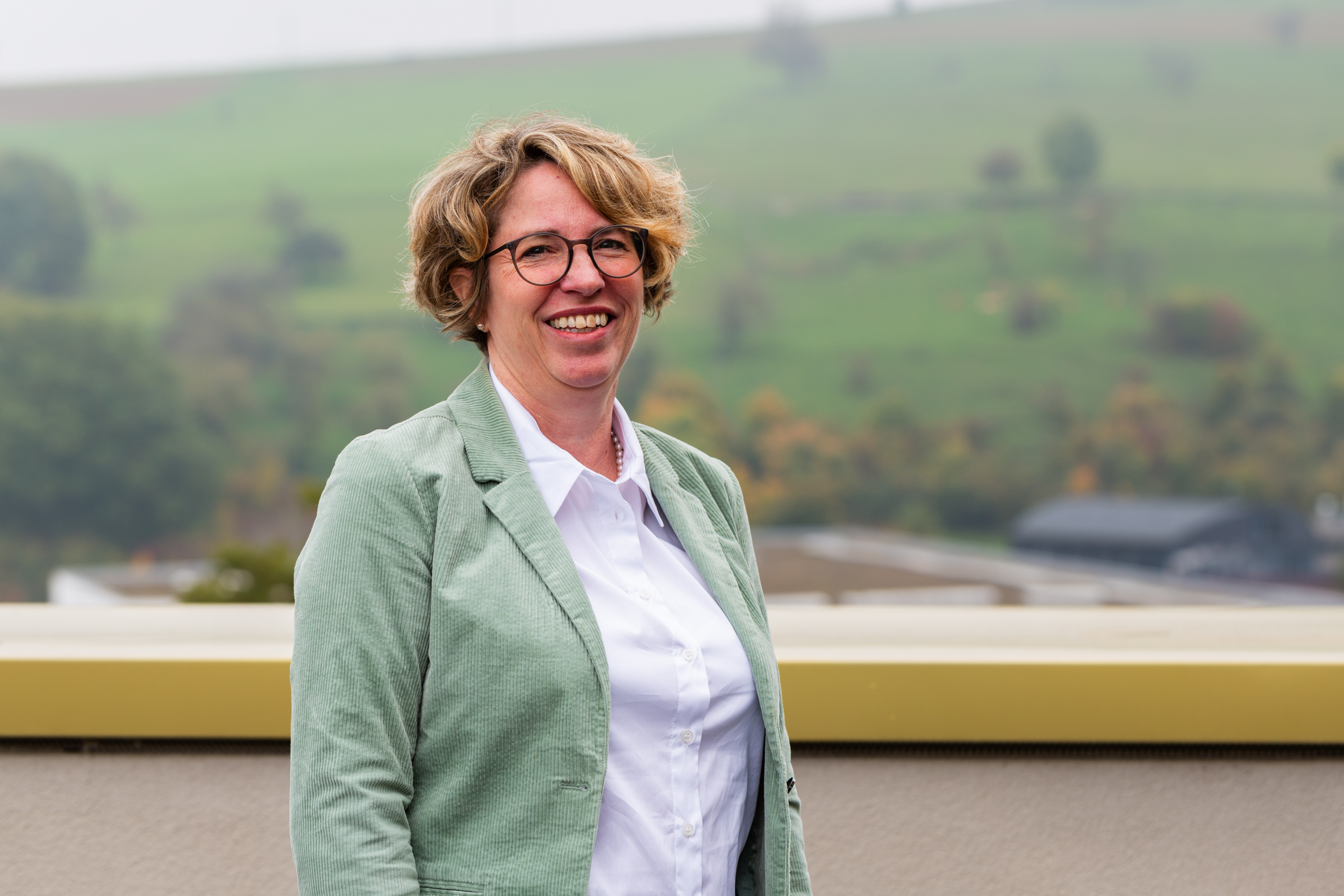 Portrait of Miriam Baumann outdoors, with a green meadow in the background