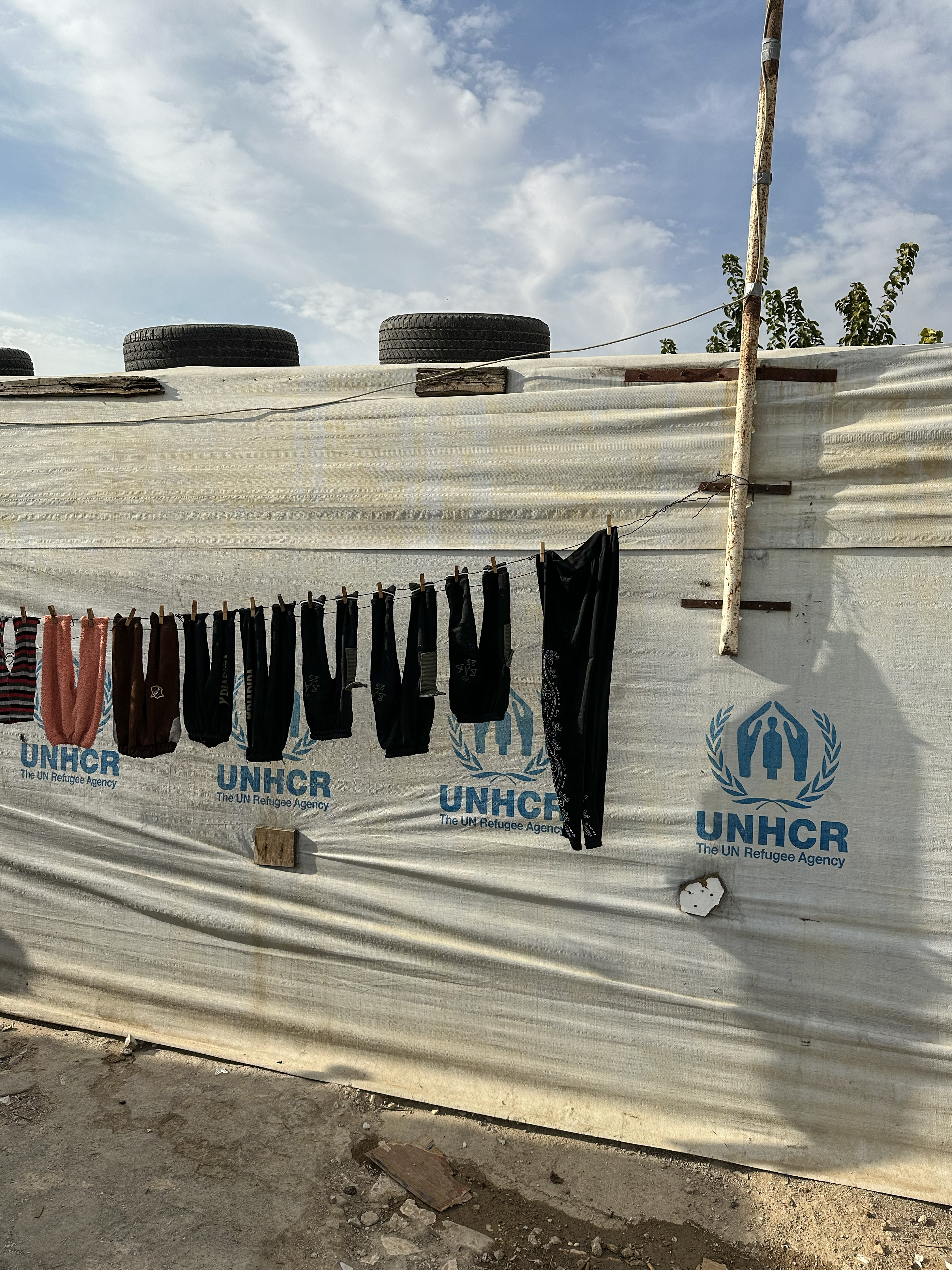 Linge lavé suspendu devant une tente