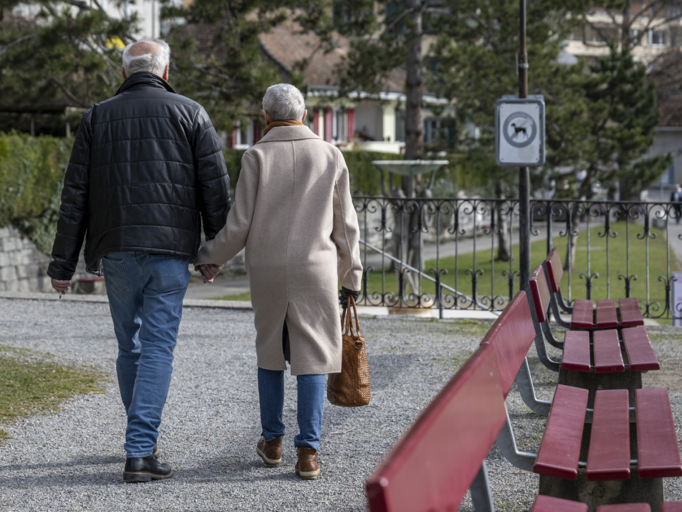 coppia di pensionati fotografati di spalle che passeggiano mano nell mano