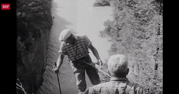 Mann seilt sich ab, um die Felswand zu putzen