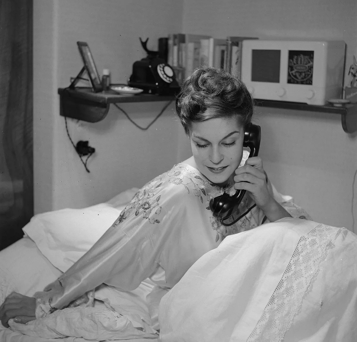 Eine Frau im Bett, die am Telefonhörer ist