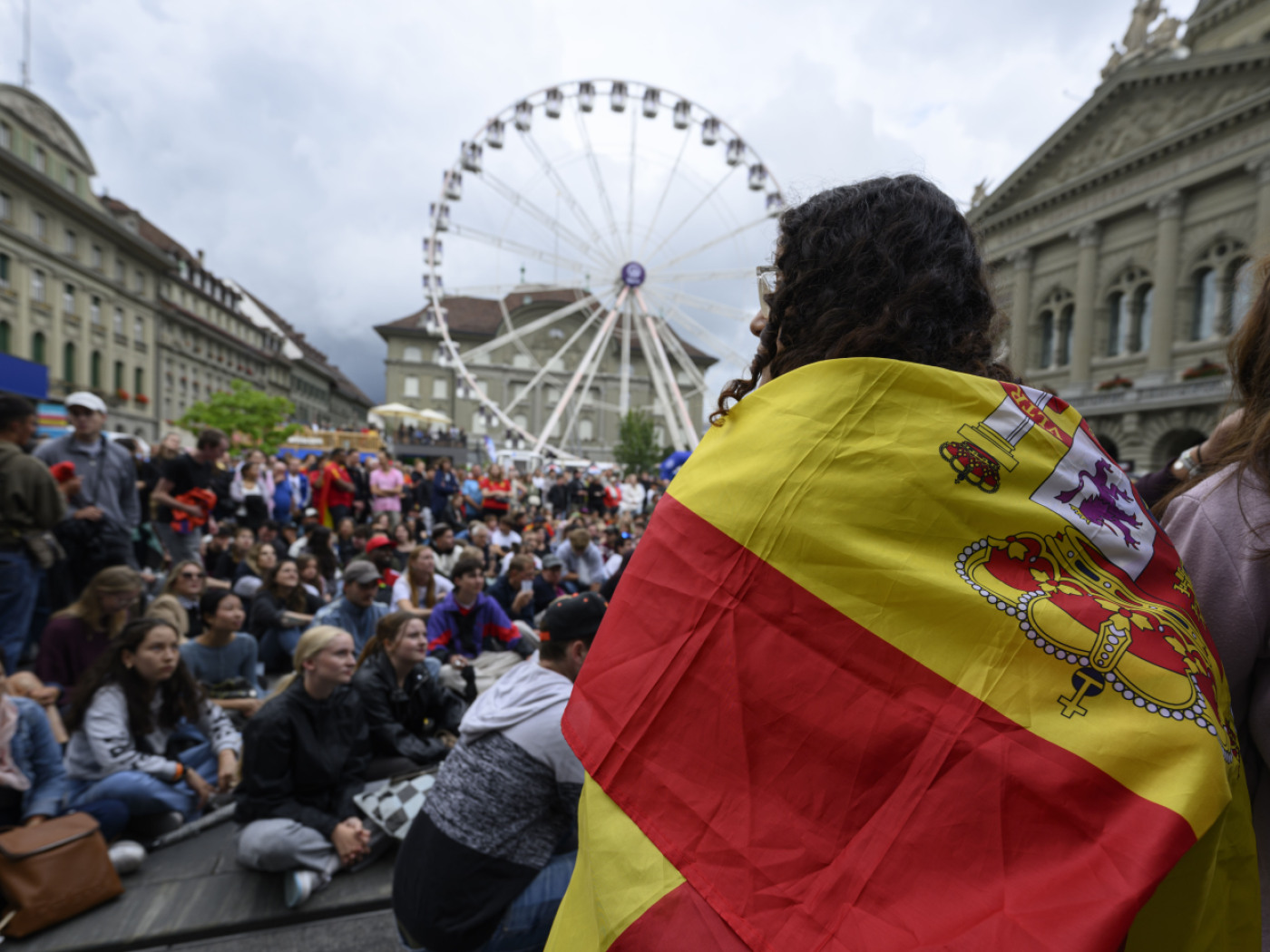 donna fotografata di spalle con abndiera spagnola sulle spalle