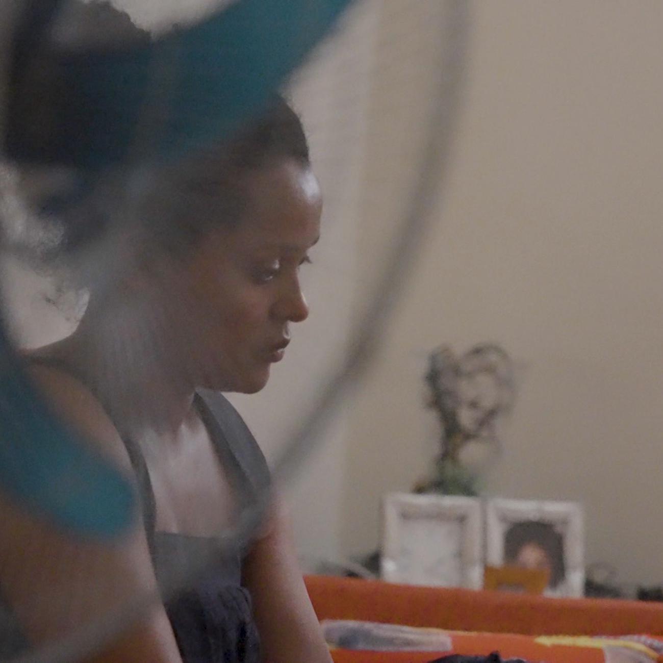 a woman sitz in front of a wall