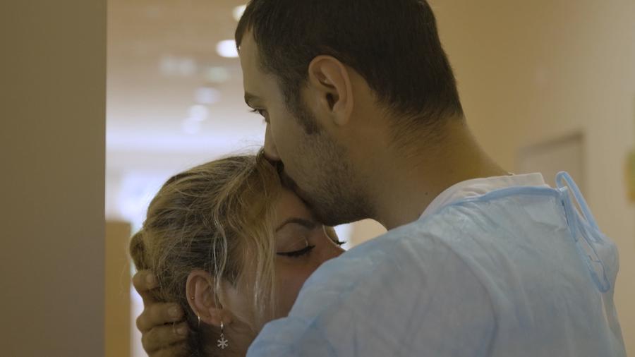 Man kisses woman on forehead