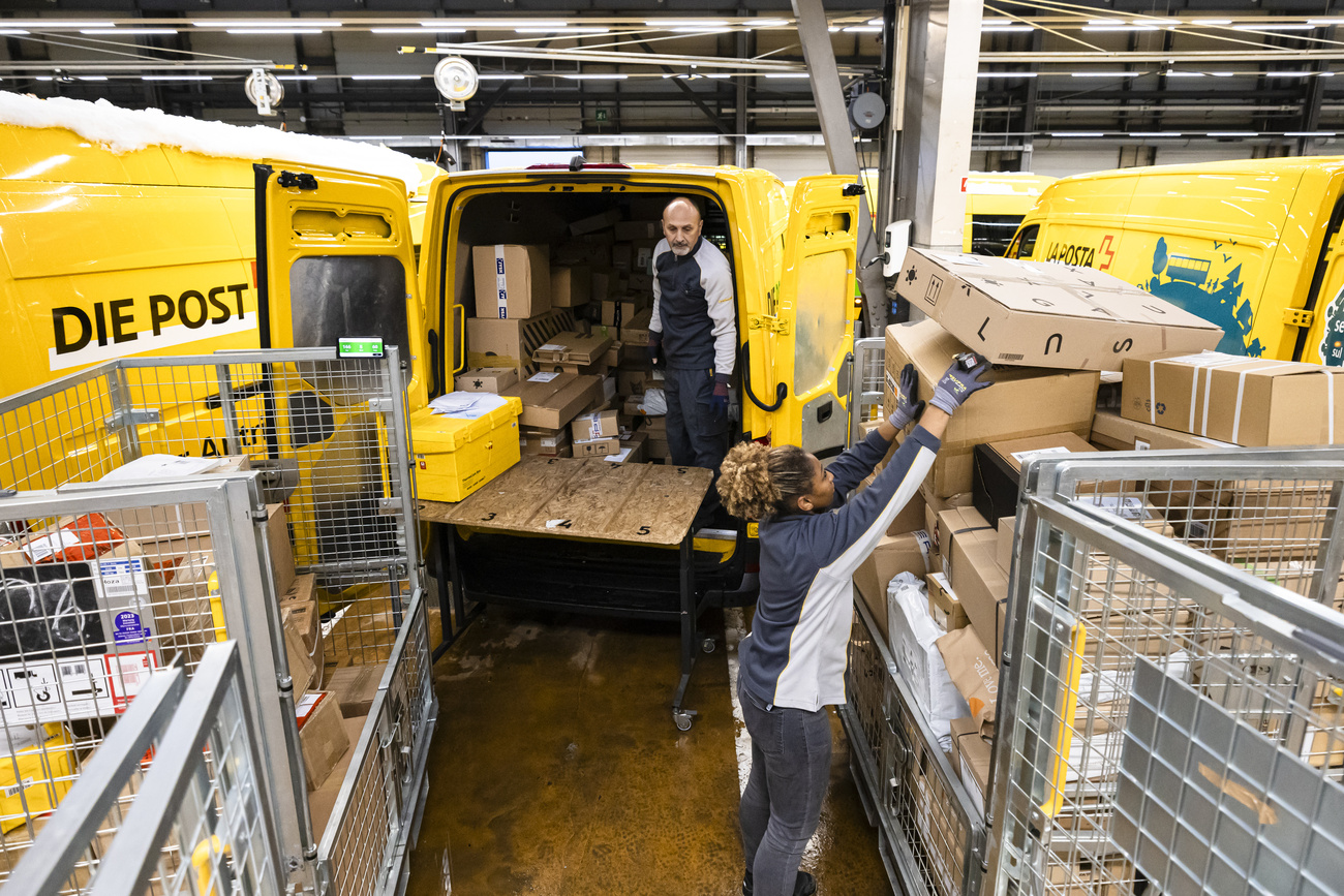 Due postini alle prese con molti pacchi.