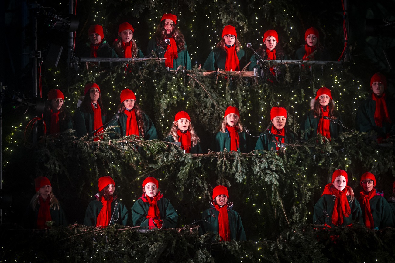 Bambine e bambini con cappelli rossi rallegrano il periodo dell'Avvento a Zurigo. Cantano sul Singing Christmas Tree, un palco a forma di albero di Natale.