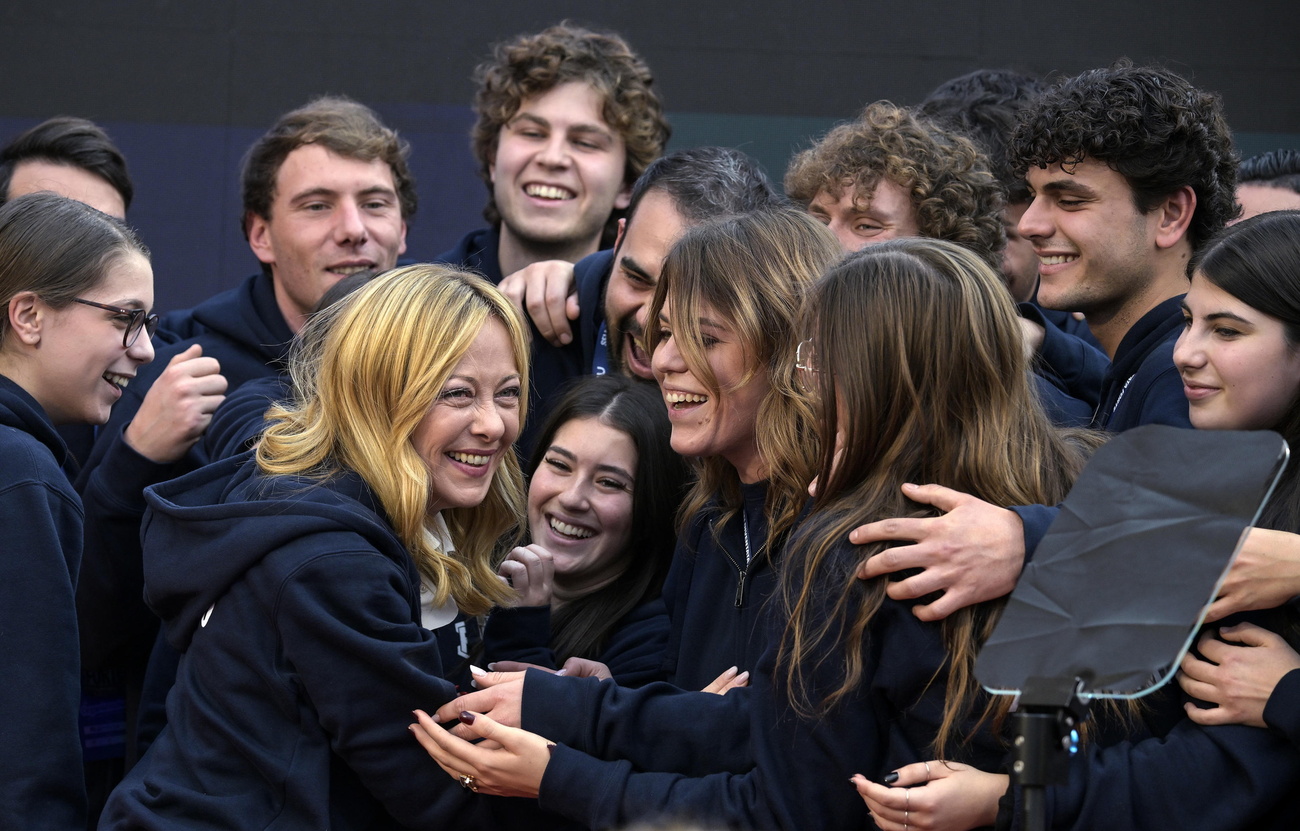 Giorgia Meloni tra un gruppo di ragazzi e ragazze entusiaste.