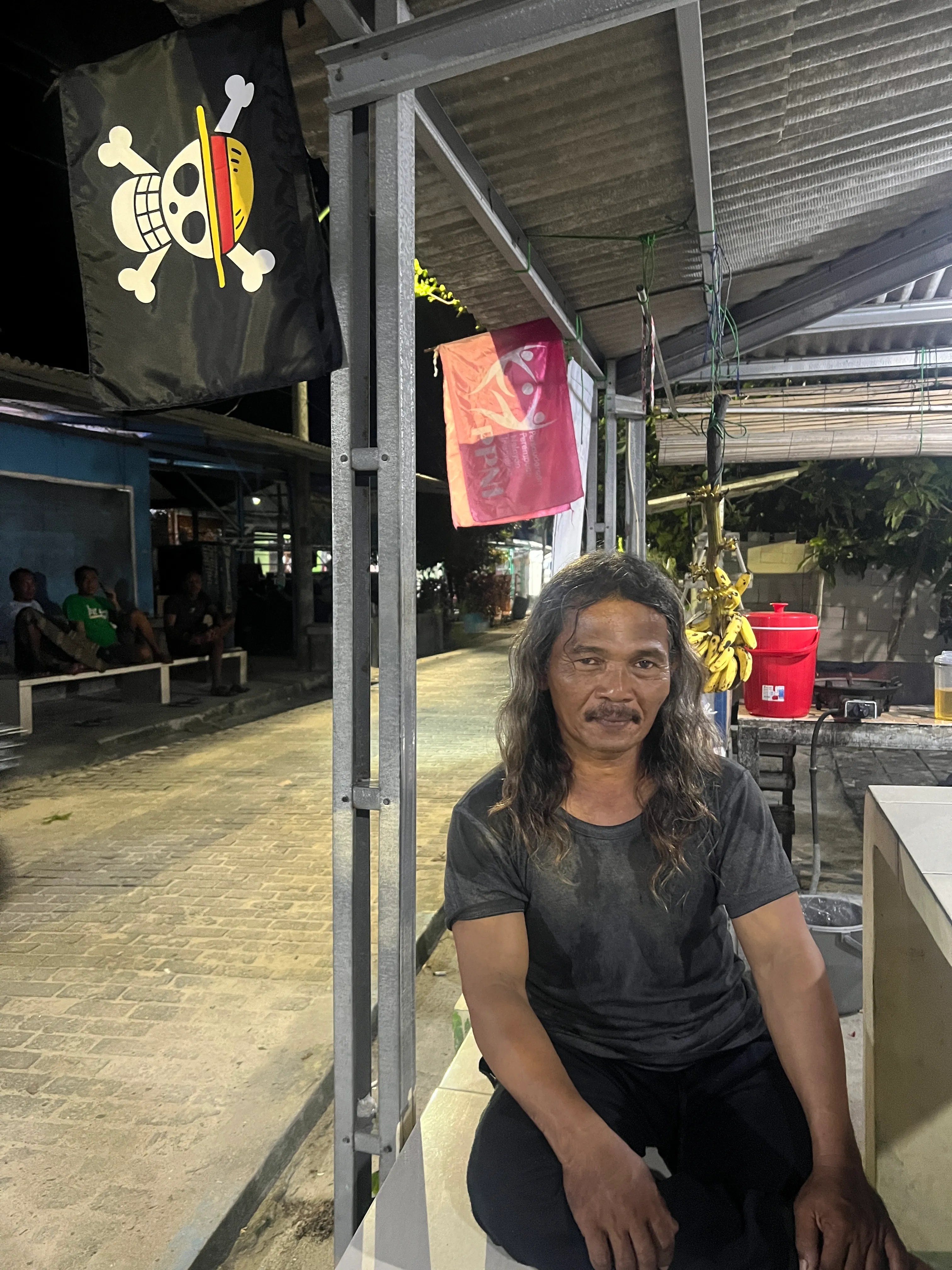 鮑比在阿斯瑪尼亞的露臺上。他身後是日本漫畫《海賊王》中的「快樂羅傑」海盜旗，這面旗幟已成為印尼氣候抗議運動的象徵。