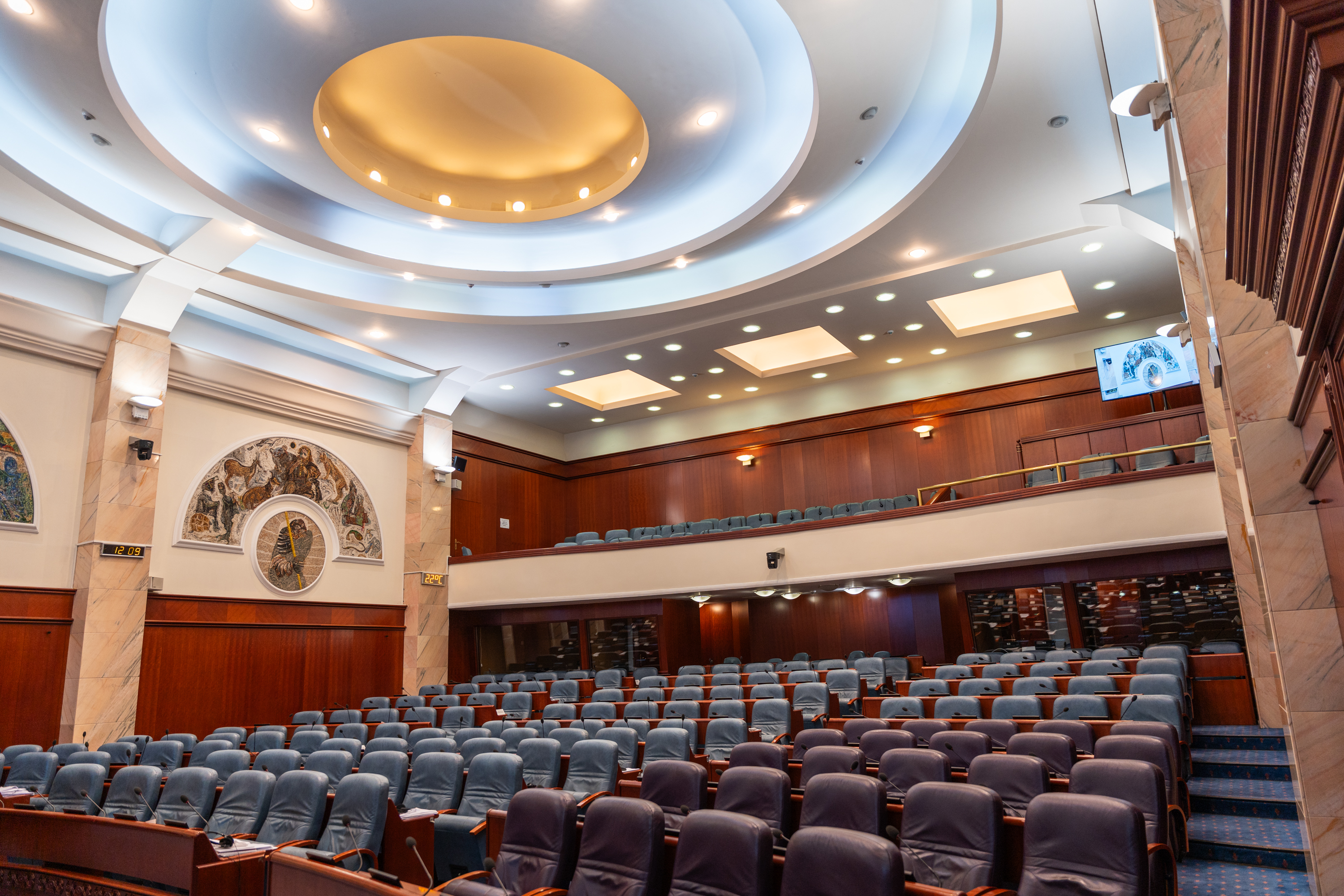L'intérieur d'une grande salle de réunion avec des rangées de sièges bleus