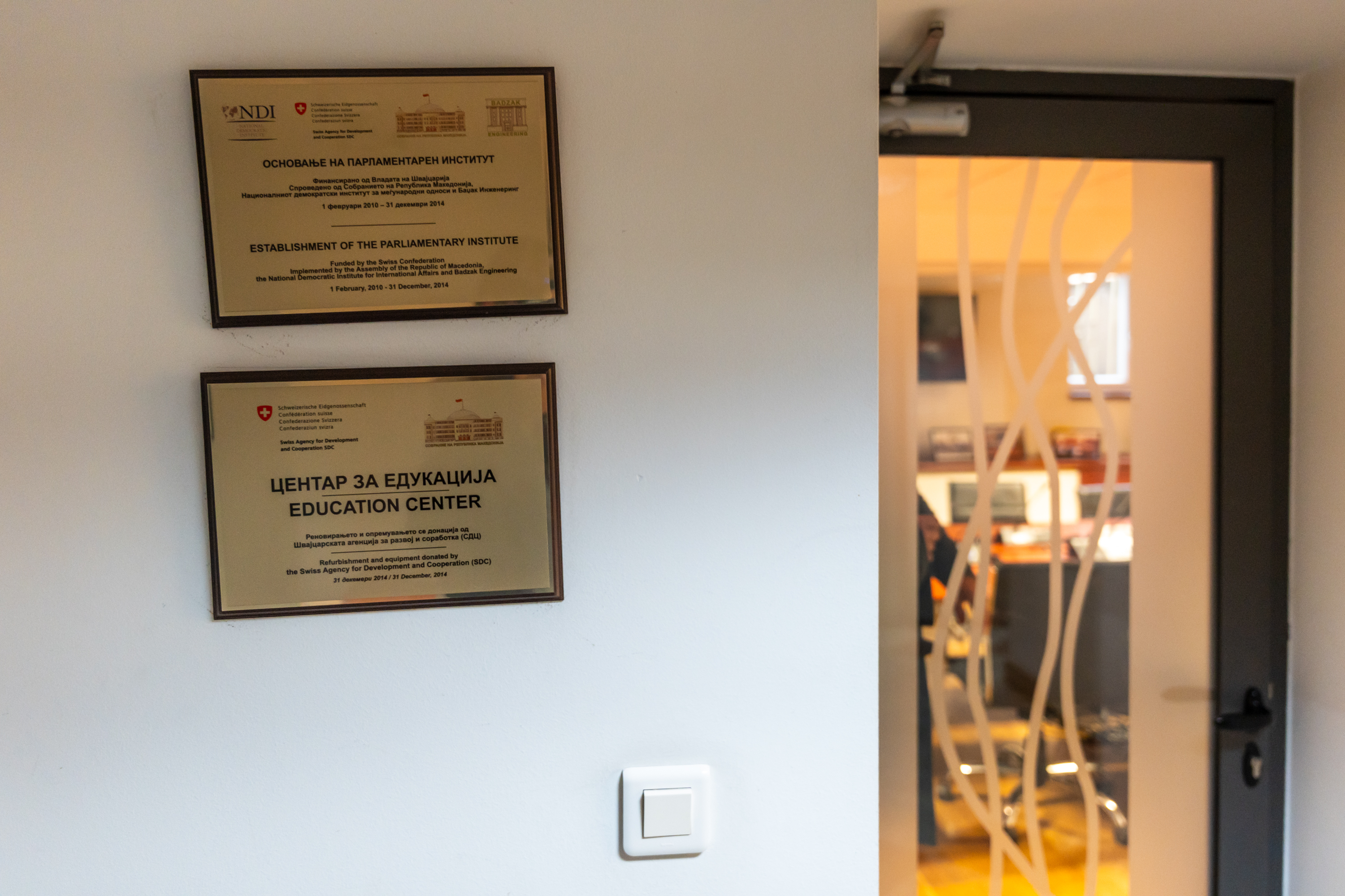 Deux plaques sur un mur et une porte menant à une autre pièce