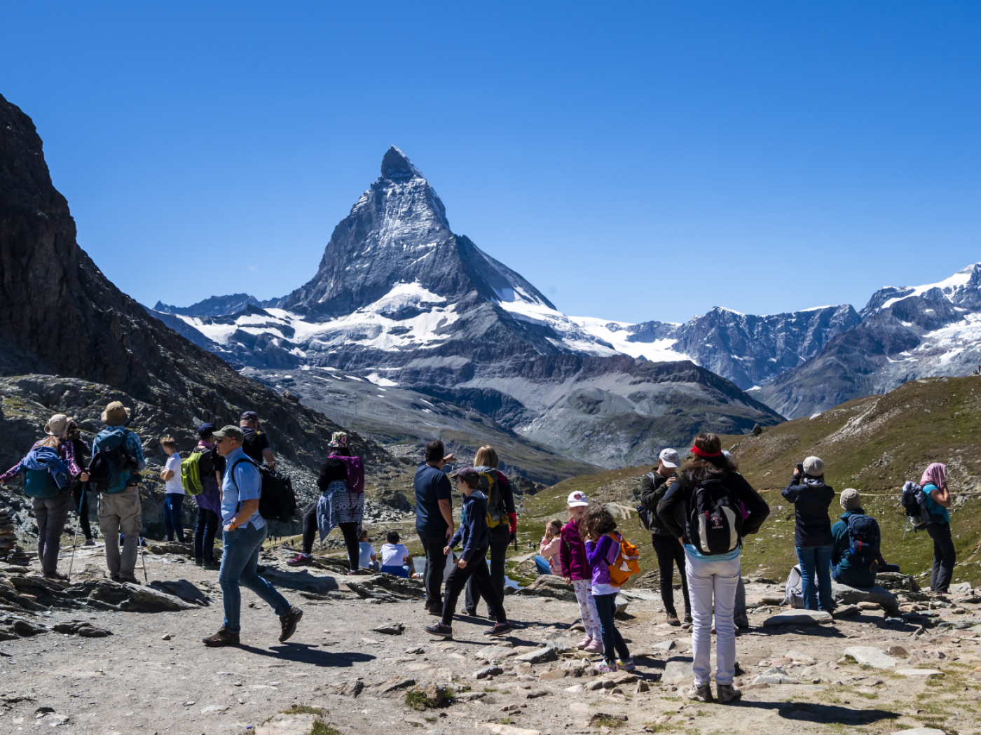turisti ai piedi del cervino in giornata estiva