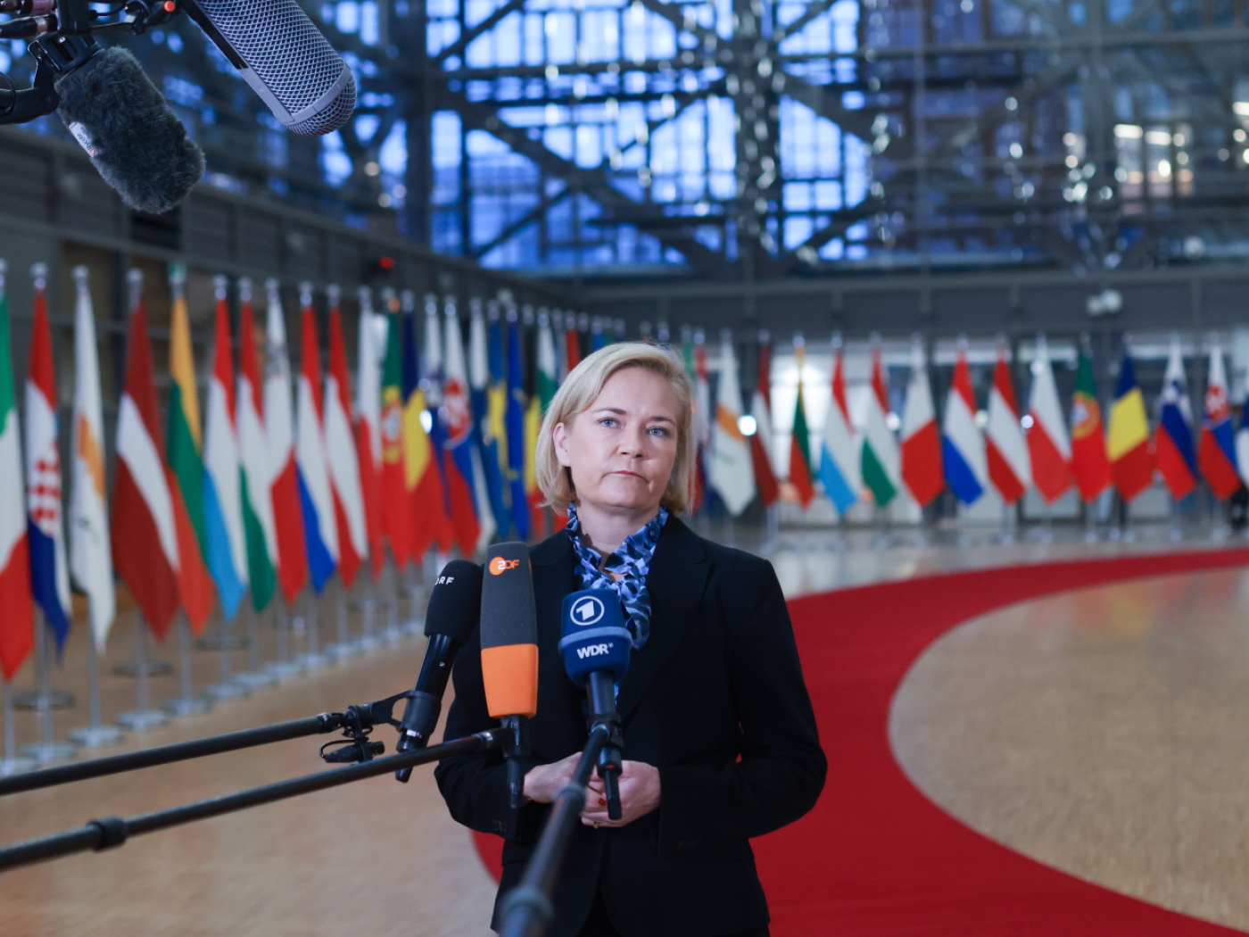 donna parla davanti a microfoni della stampa