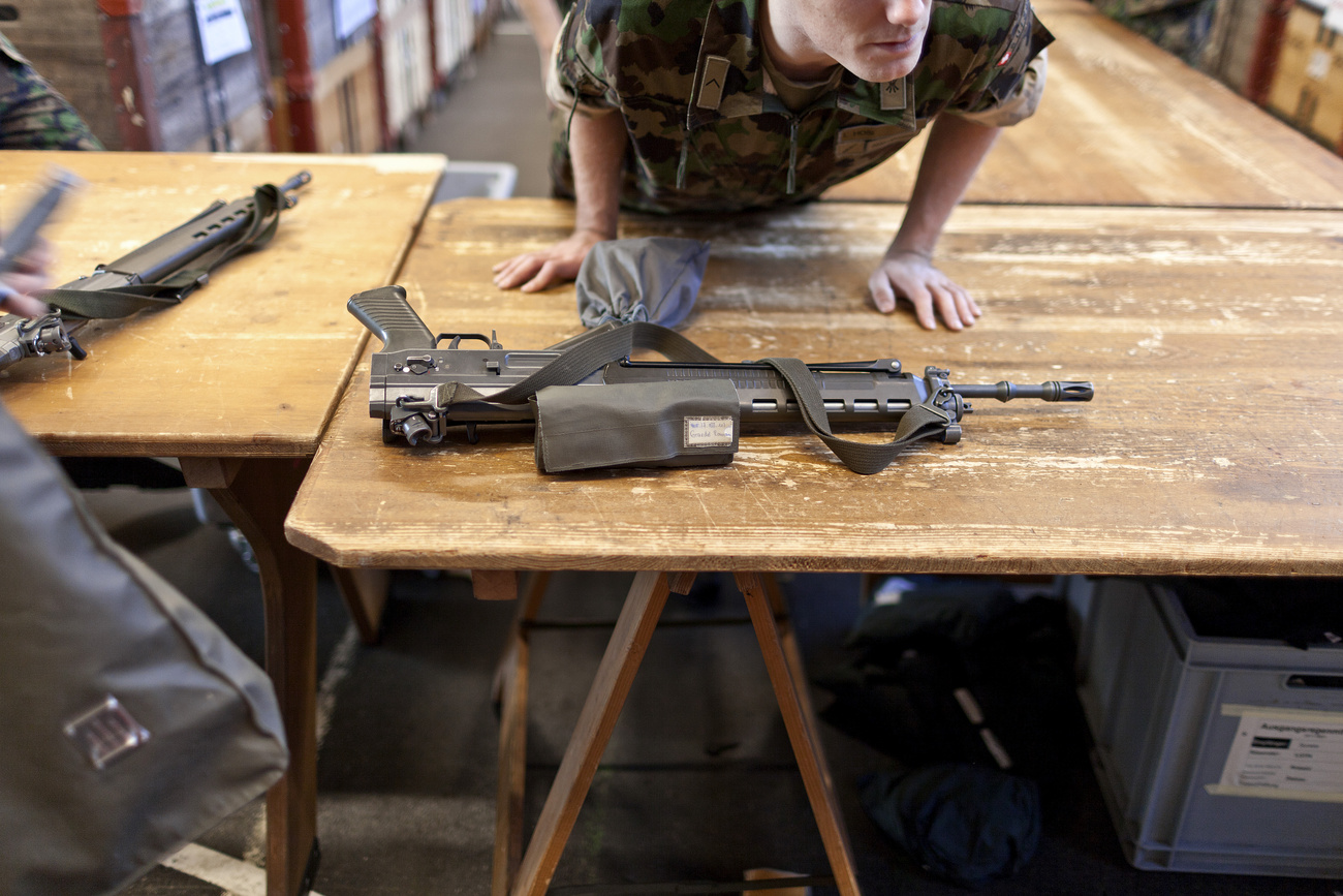 Soldato dietro a un tavolo su cui è posato un fucile