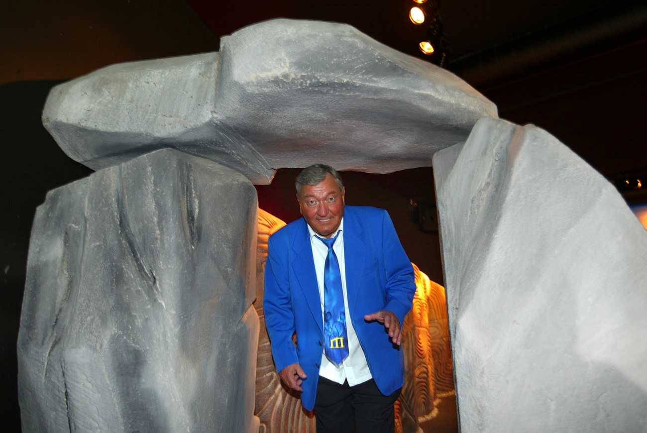 Persona in giacca blu sotto dolmen finto