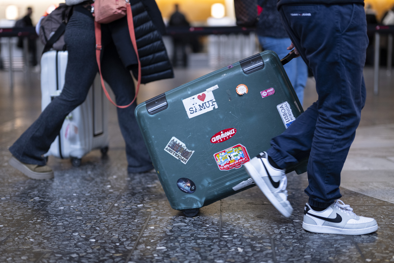 valigia trascinata da un viaggiatore