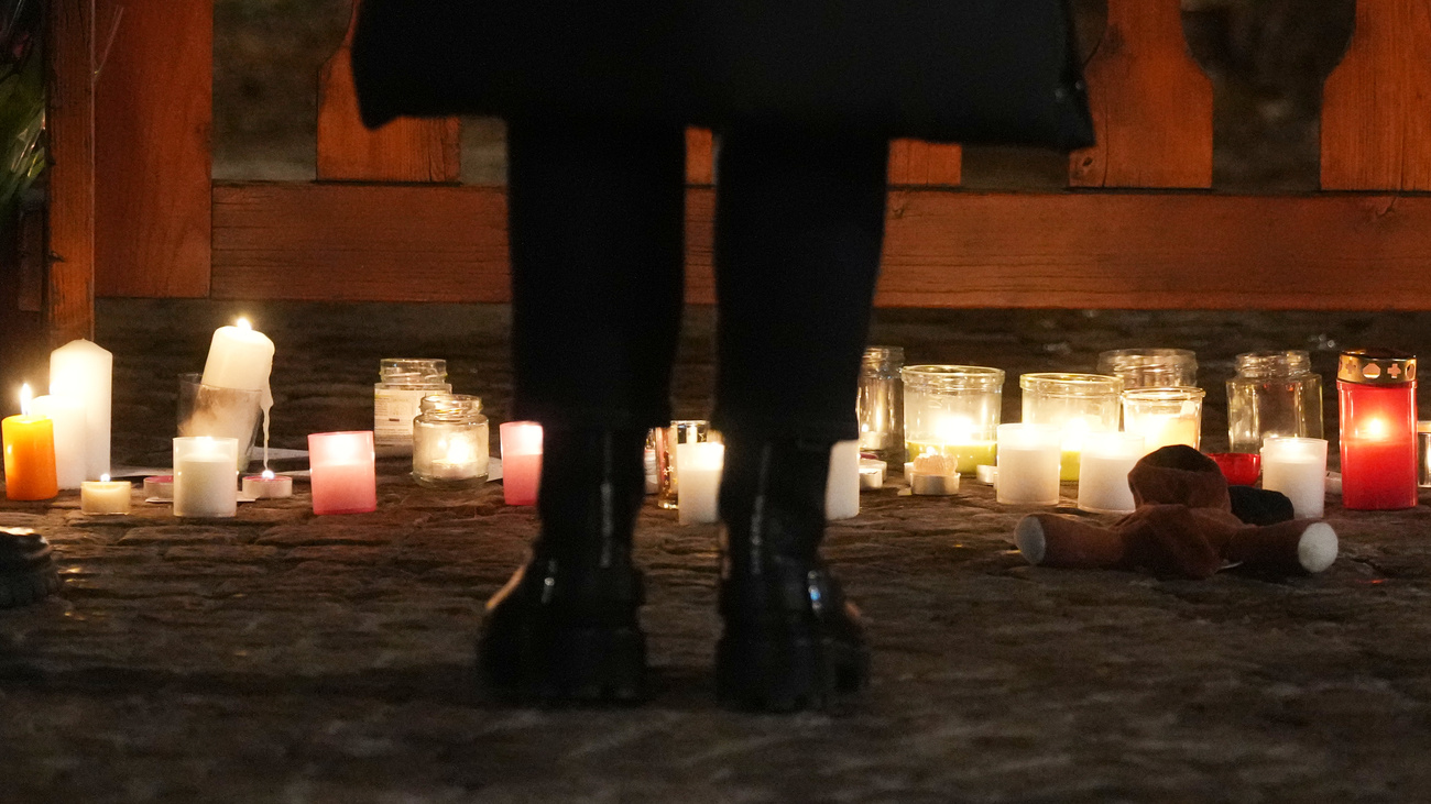 persona in piedi davanti a candele a crans montana