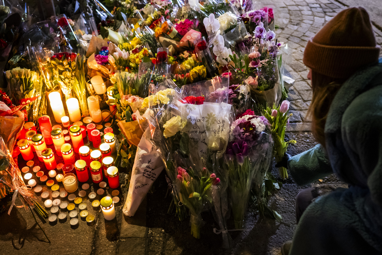 Eine Frau legt Blumen nieder