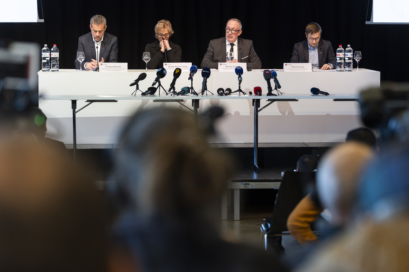 Conferenza stampa, persone dietro a tavolo con microfoni