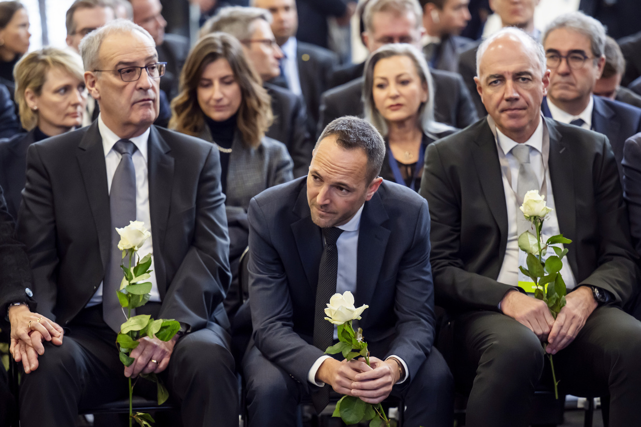 El presidente suizo Guy Parmelin (izquierda), Mathias Reynard (centro), presidente del Ejecutivo cantonal del Valais, y Christophe Darbellay (derecha), miembro del Ejecutivo del cantón del Valais, entre los asistentes a la ceremonia oficial conmemorativa y a la jornada nacional de duelo tras el incendio mortal en el bar “Le Constellation” de Crans-Montana. La ceremonia tuvo lugar en el Centro de Exposiciones y Convenciones Martigny Expo (CERM), en Martigny, Suiza, el viernes 9 de enero de 2026.