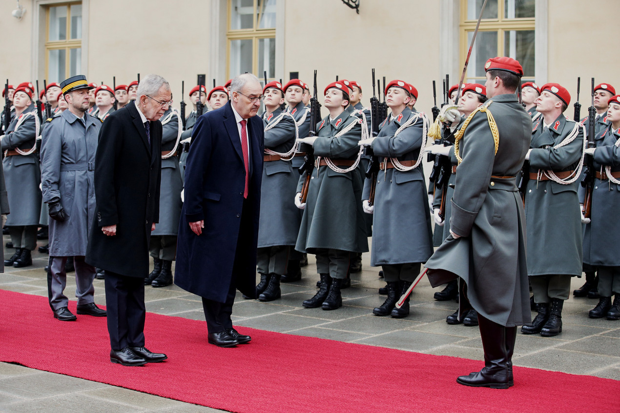Persone in completo davanti a soldati sull'attenti