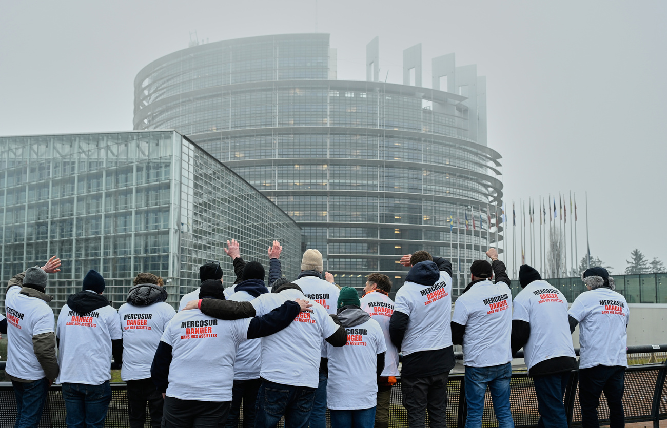 Pessoas protestando frente a um edifício