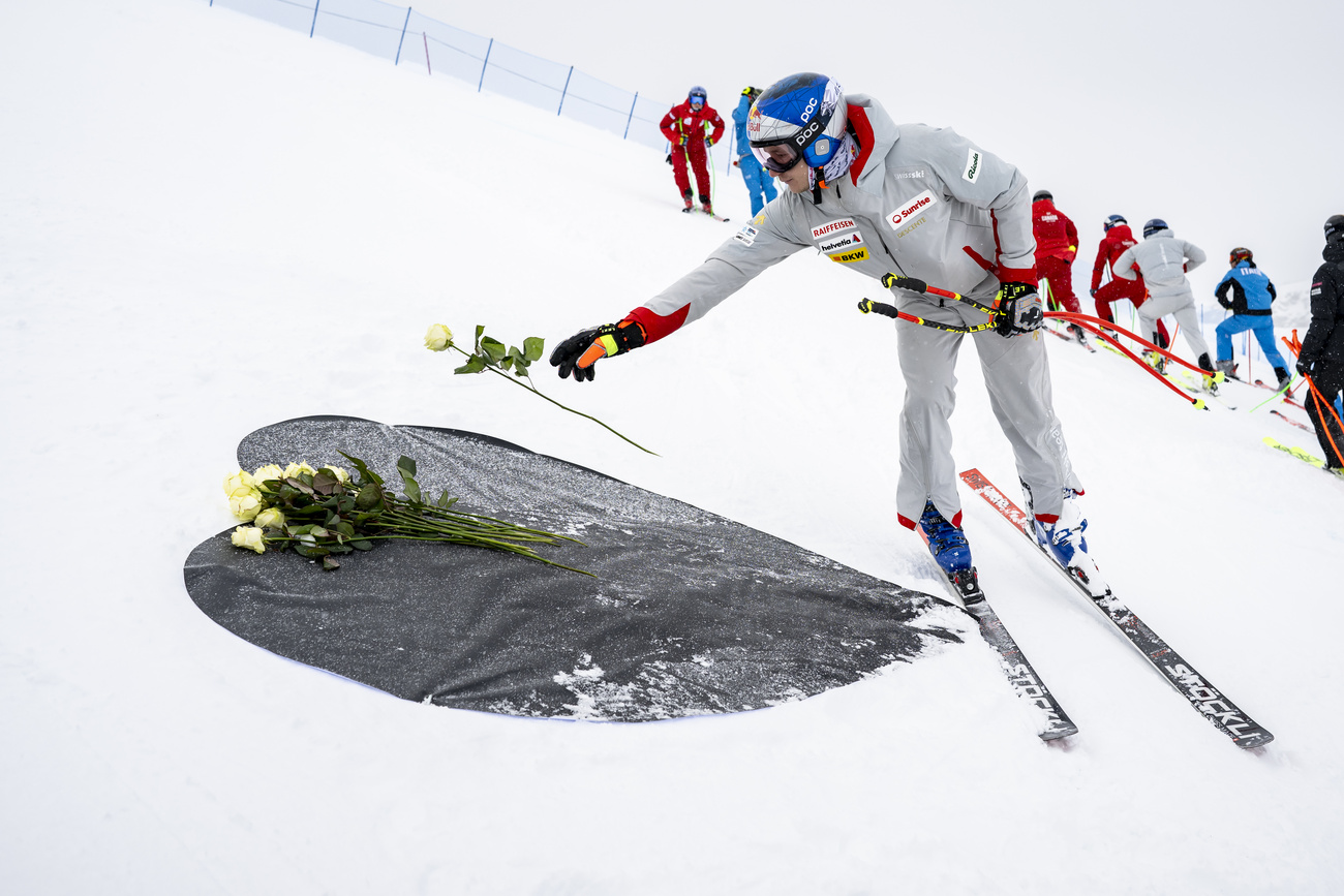 Ricordando le vittime dell'incendio: La stella dello sci svizzero Marco Odermatt depone una rosa durante l'allenamento di discesa.