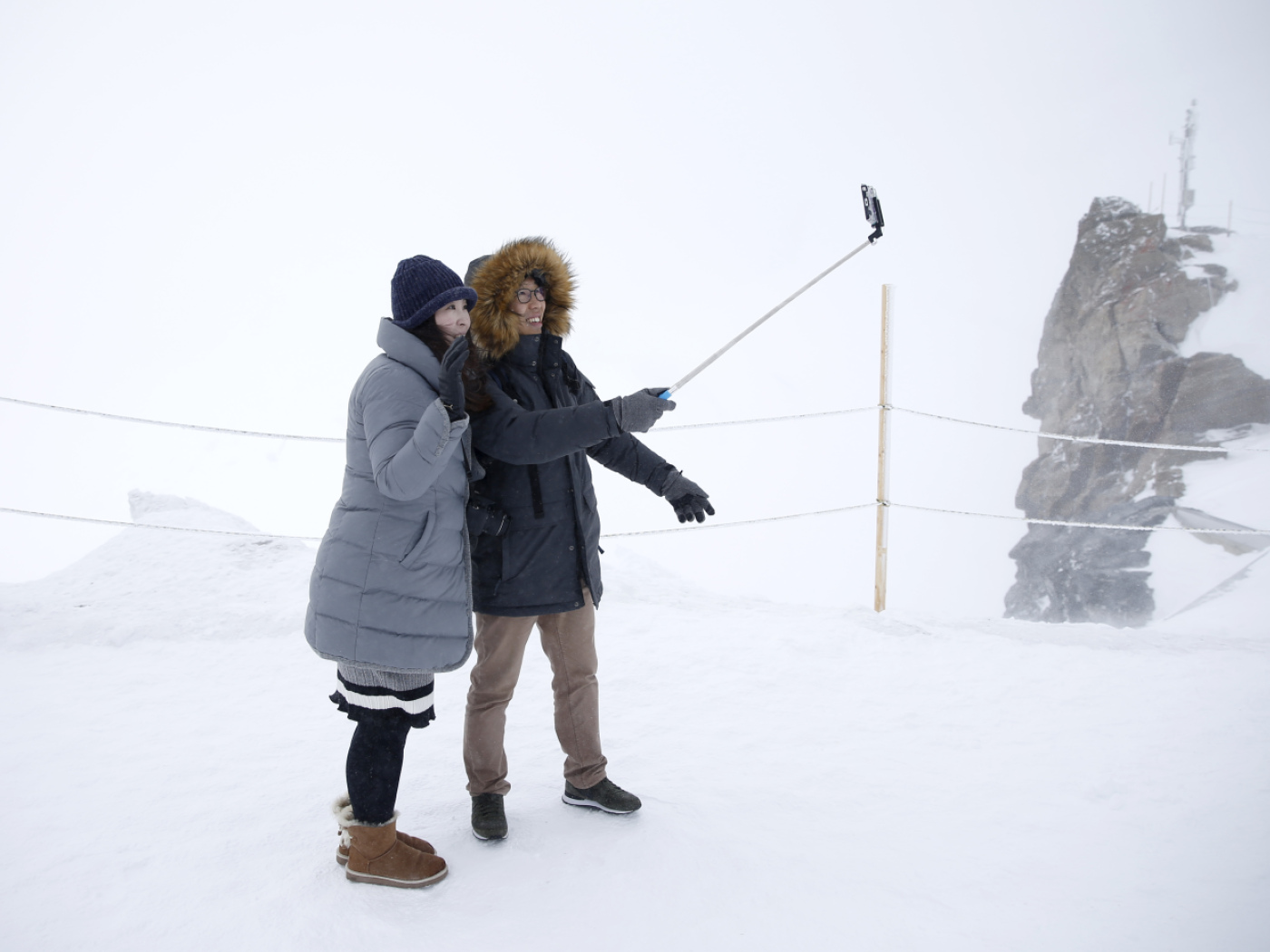 turisti asiatici si fanno un selfie con un selfiestick in paesaggio invernale innevato