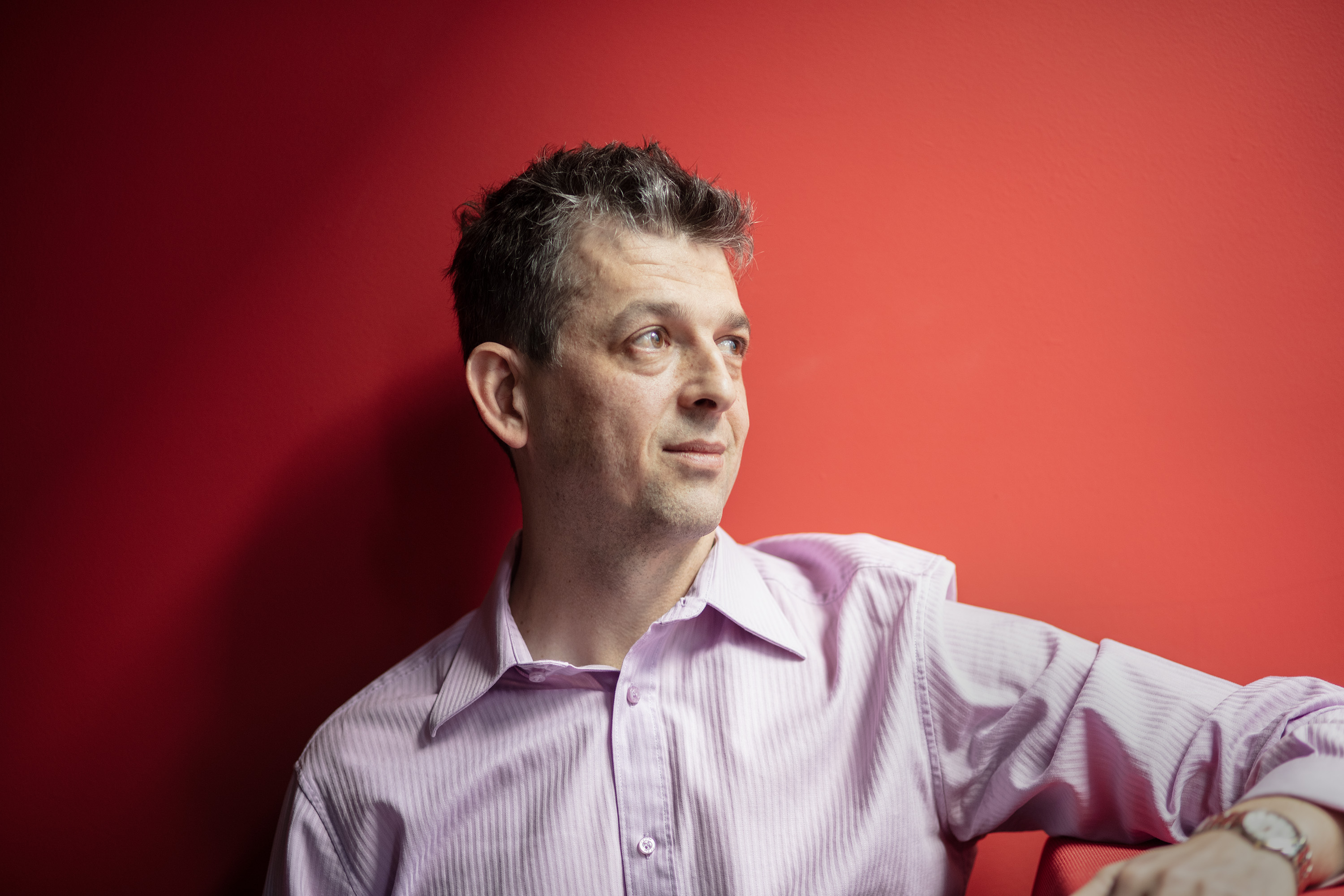 man in front of red wall