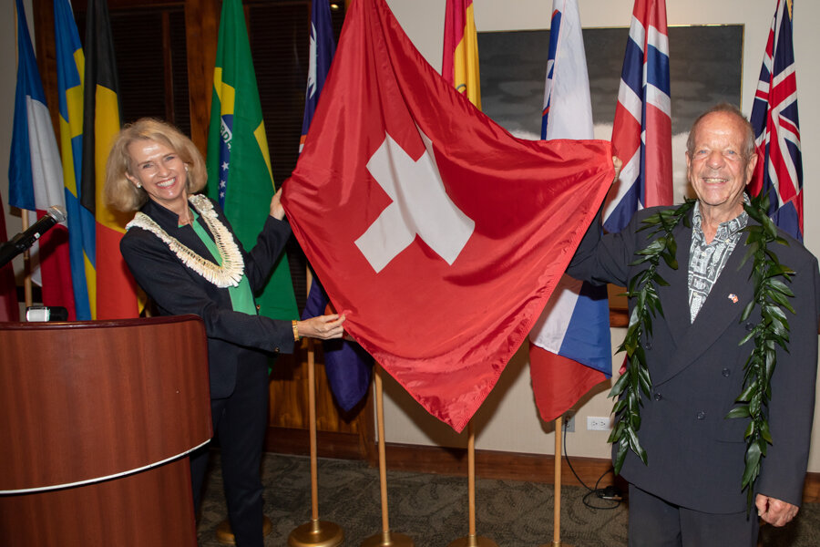 Une femme et un homme tiennent un drapeau suisse