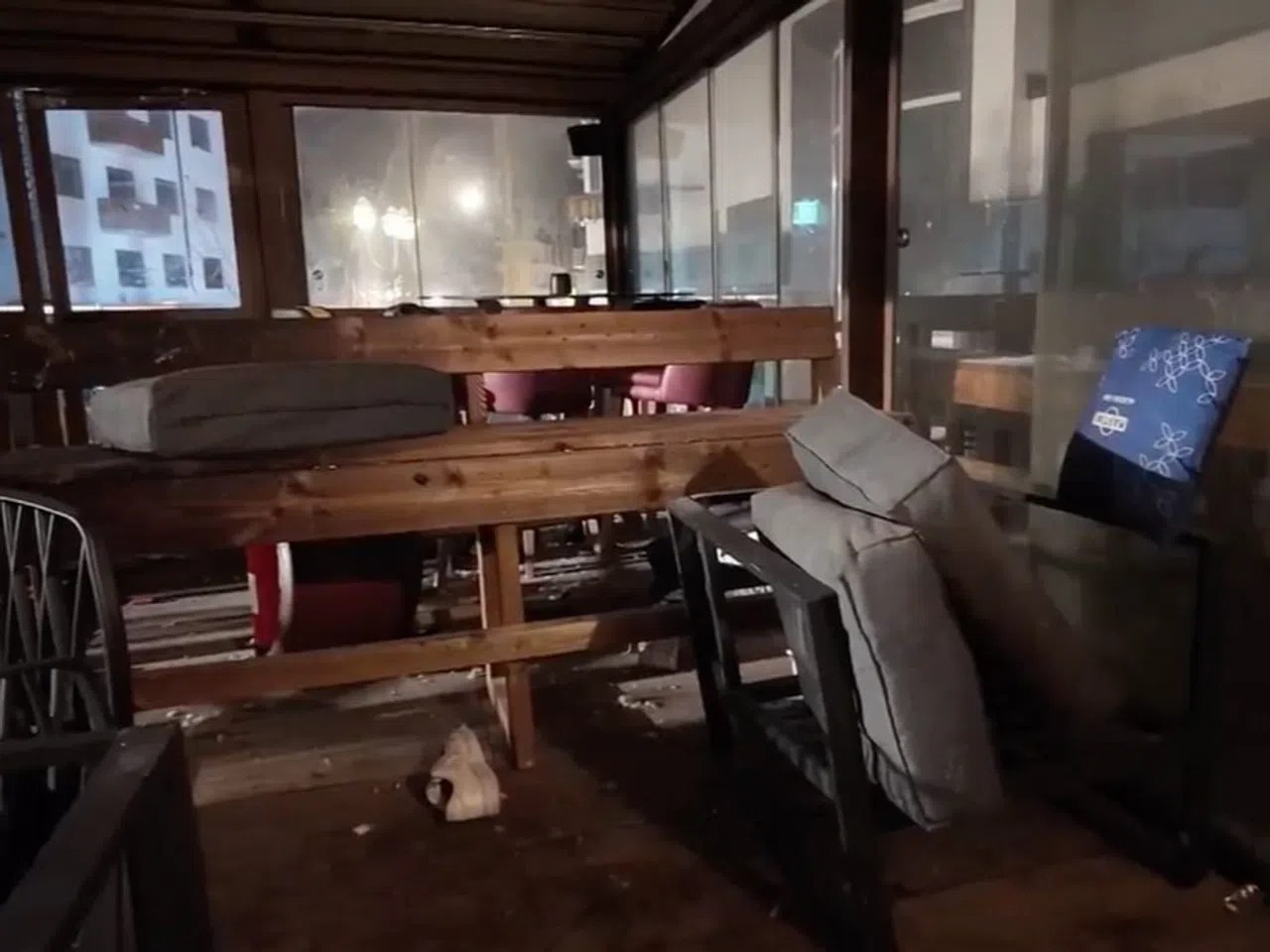 Chaotisch zurückgelassene Stühle, angelaufene Scheiben, ein Turnschuh: Blick in das Innere der ausgebrannten Bar «Le Constellation». Das Bild wurde von der Kantonspolizei Wallis veröffentlicht.