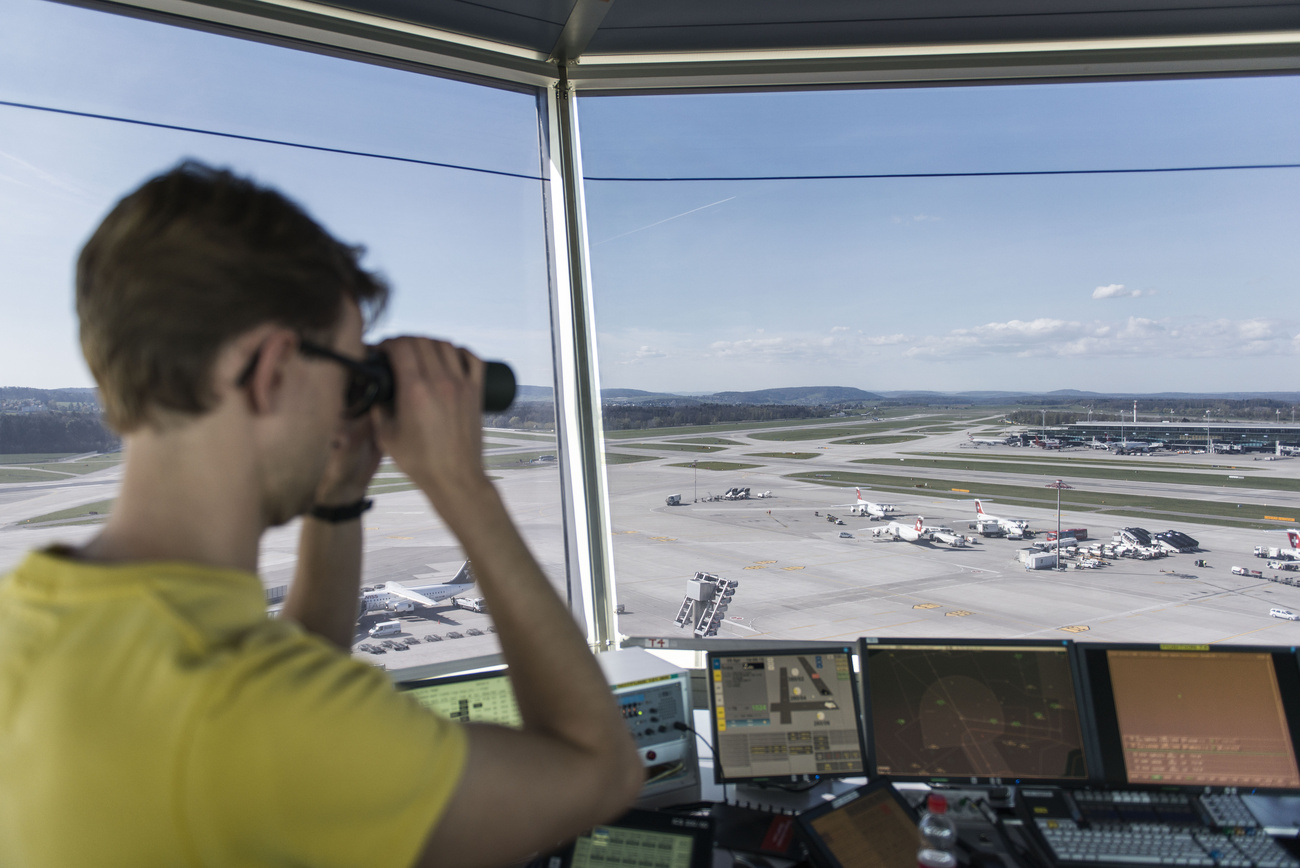 Persona con binocolo all'interno di una torre di controllo