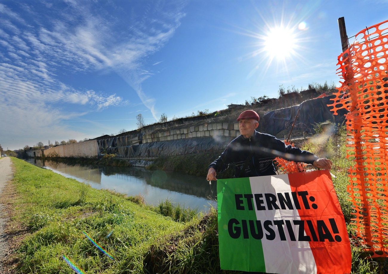 uomo tiene bandier italiana con scritta ETERNIT GIUSTIZIA