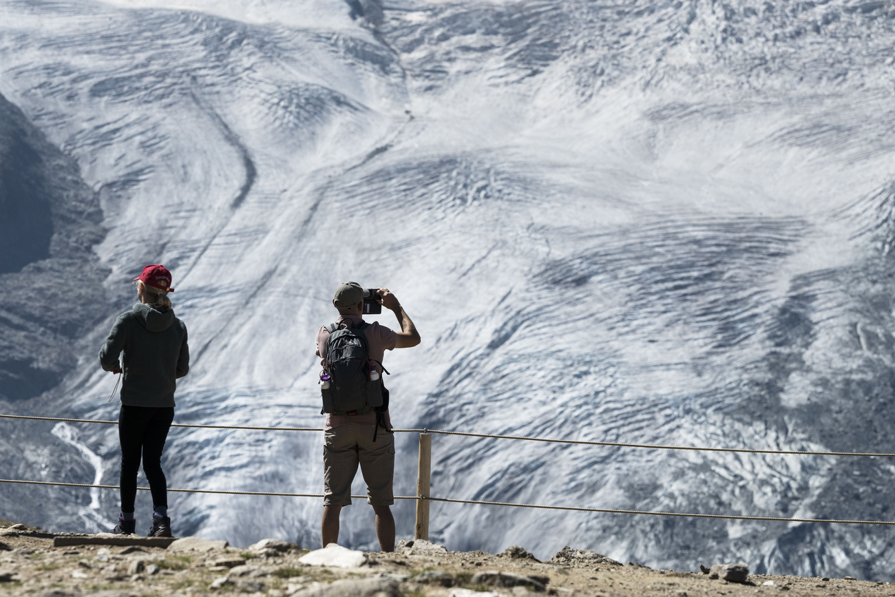 turista fotografa un ghiacciaio