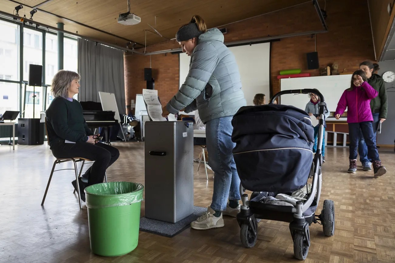 2024年3月，一位媽媽推著童車來到伯恩一處投票點投票。投票日當天很重要，但為了確保公投的公平性，投票前後的階段也至關重要。