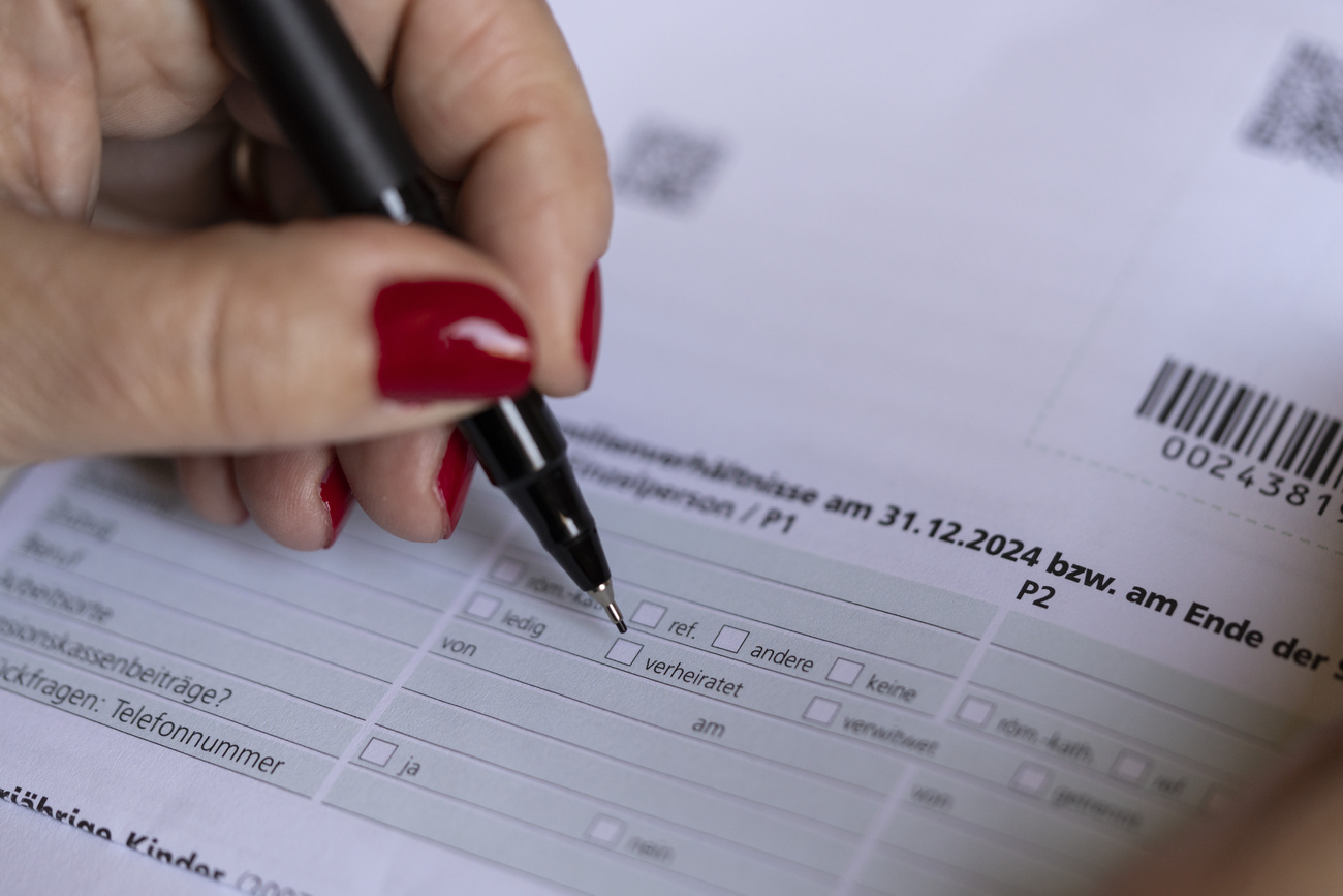 Eine verheiratete Frau füllt die Steuererklärung aus und kreuzt den Zivilstand "Verheiratet" an, nur die Hand ist sichtbar